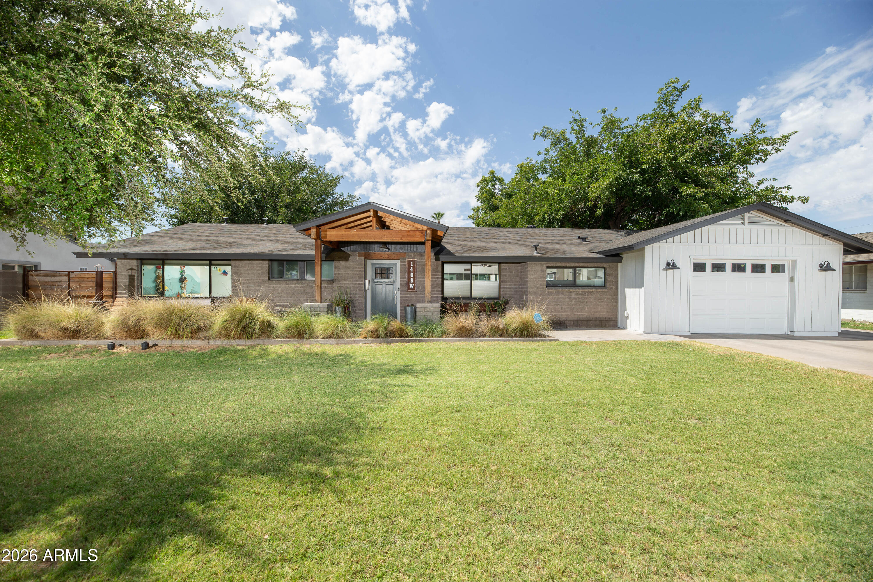 This is a beautifully renovated ranch home that has been modified perfectly for modern day life on an irrigated lot with mature trees. Great curb appeal welcomes you into a great room with vaulted ceilings and an expanse of glass overlooking the large covered patio and private yard. Upgrades include dual pane windows, newer a/c, new roof, sewer relining, upgraded panel doors and updated kitchen and two exquisitely tiled baths. The primary suite is a haven within itself with a huge ensuite bath with sep toilet room, w/in shower ,full wall of vanity cabinets w/dual sinks and a soaking tub promising quiet time. There are two w/in closets and views of the lush yard. Both secondary bedrooms feature custom murals. A hidden gem is the separate 478 sq foot garage/workshop with access to the alley!