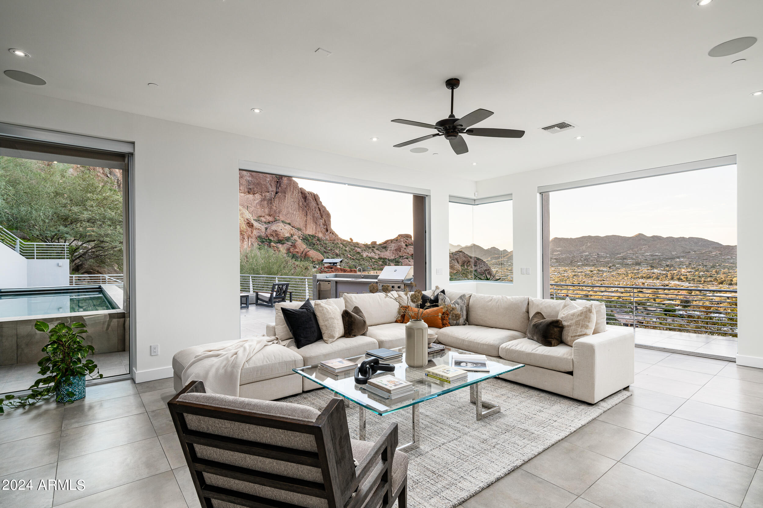 Perched high on the side of Camelback Mountain, this stunning fresh contemporary is unmatched in every way.  Nestled below the Praying Monk & surrounded by 1.78 acres of peace & serenity offering breathtaking city lights, sunsets & dramatic mountain silhouettes. The modern design's pocketing walls of glass combine indoor & outdoor living at it's finest. The spacious kitchen has a magnificent 24' waterfall island, complete with sit-up bar. The stunning upstairs primary retreat sports a wraparound view deck, spacious white marble bathroom, soaking tub with mountain views & outside shower. Each en-suite bedroom is intelligently placed and offers their own unique finishes. The outdoor living spaces are perfect for cozy get togethers or large corporate parties featuring several covered and open air decks with multiple fire-pits, BBQ station & covered lap pool. Combining both functionality and convenience, notable features of this home include an elevator, two powder rooms and a pool bath, lower level game room, dedicated office or 5th bedroom and a three car tandem garage.