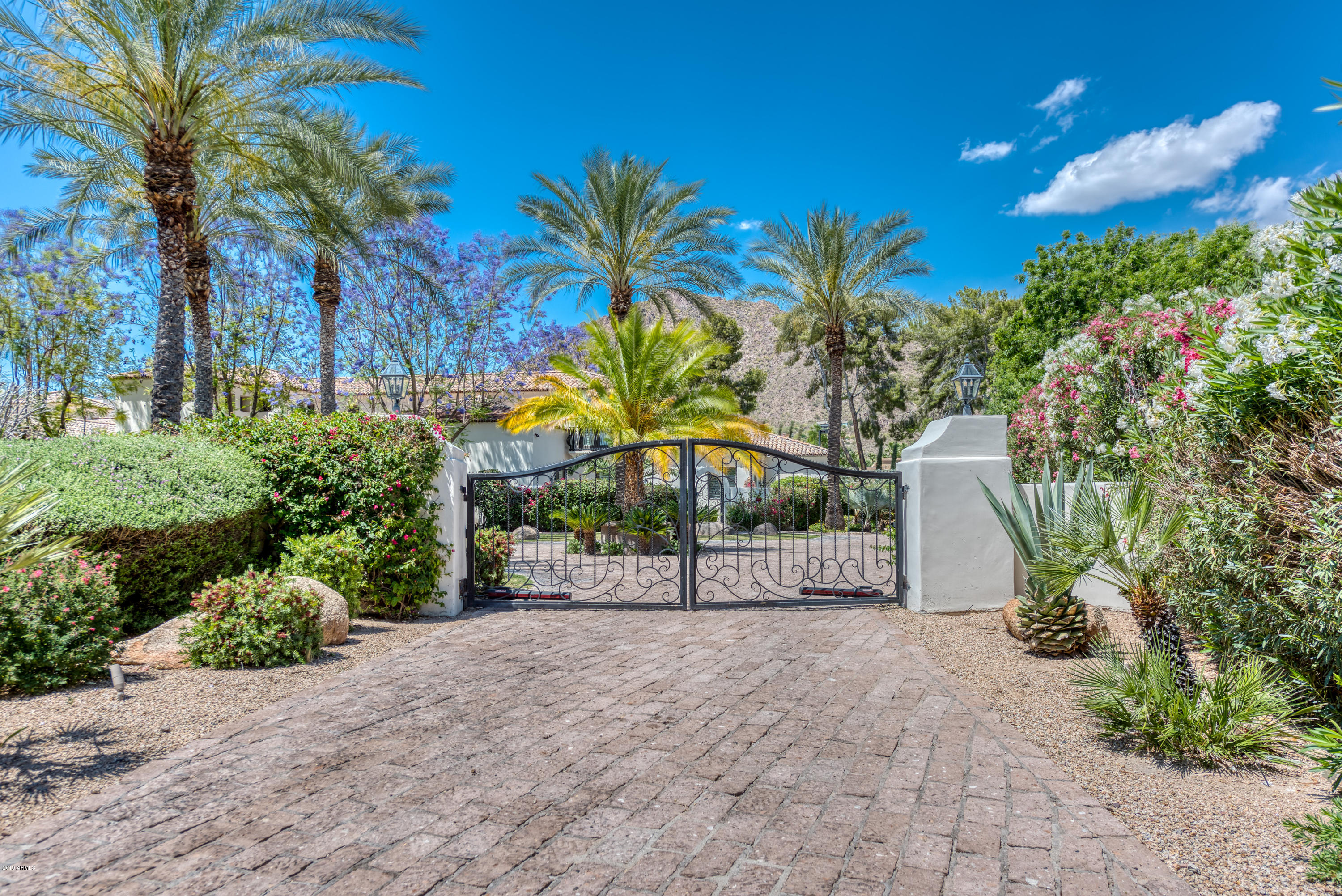 Tucked away on a private cul-de-sac lot in the heart of Arcadia sits this stunning Santa Barbara estate.  From the moment you enter the iron gates you are greeted by a breathtaking environment of lush grounds that give way to Camelback Mountain views.  This one-of-a-kind estate boasts quality finishes throughout and large living spaces that include a game room, workout room, and multiple en-suite bedrooms.  The incredible master retreat is designed with his/hers bathrooms and closets, as well as a separate living room with spectacular views.  The guest bedrooms upstairs all have Camelback views with private balconies.  In the backyard you will enjoy the grand patios, sparkling pool, sport court, and batting cage.  Call today to schedule an appointment!