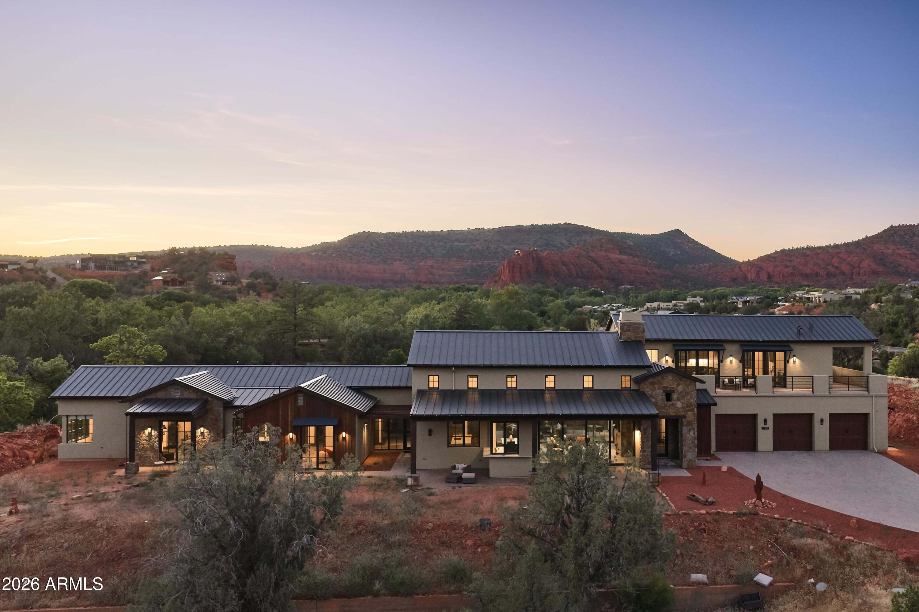 Nearly 12 acres of Sedona that cannot be reassembled. Two contiguous lots inside gated Sedona Ranch on Oak Creek, bordered on two sides by Coconino National Forest and adjacent to Red Rock State Park; a permanent buffer no future development can undo. Private creek frontage with its own beach, a mature sycamore corridor, a recognized vortex site, and a red rock quarry on the land. 360-degree views gather Cathedral Rock and the surrounding monoliths. Heinrich Schuerman planted Arizona's first commercial vineyard along this stretch of Oak Creek in the 1880s; established irrigation rights remain. A 4,414-square-foot 2022 modern farmhouse sits lightly on the high ground, with a second home site fully prepared. Paved, gated, creek, privacy, legacy. Not a parcel, sacred land.