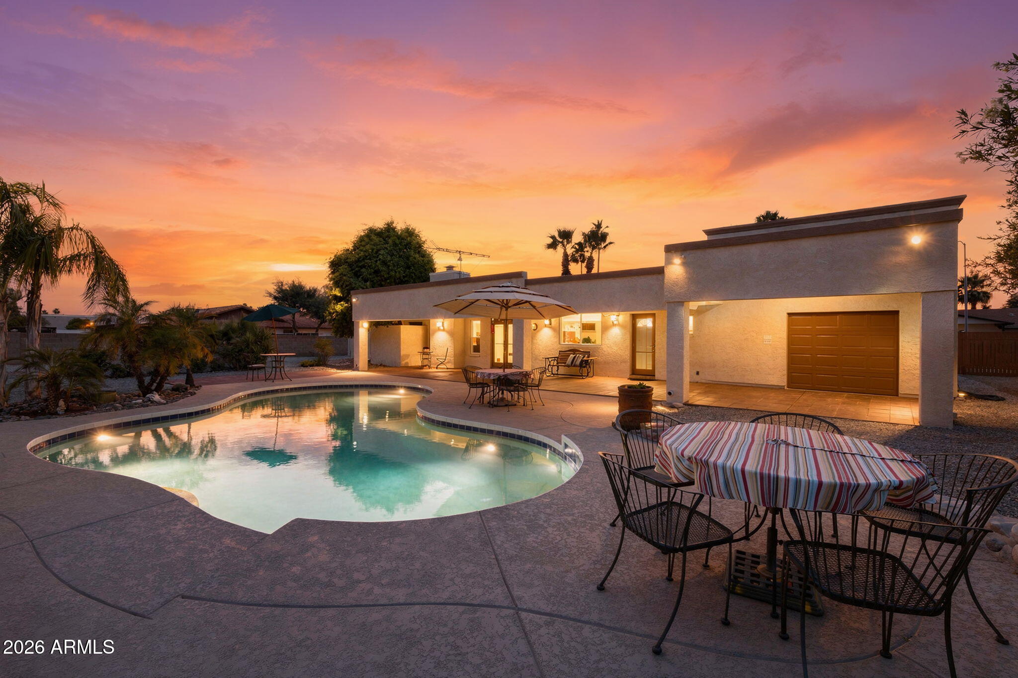 Open, welcoming, and beautifully updated, this Glendale home offers the space, comfort, and functionality buyers are looking for. From the remodeled chef's kitchen to the expansive backyard pool retreat, every detail invites you to settle in and enjoy Arizona living. A rare oversized garage with 12-foot height, rear access, and RV gate makes this property truly stand out. Welcome to this wonderful Glendale home offering 2,502 square feet of thoughtfully updated living space on an expansive 18,000-square-foot lot. Built with solid block construction, this home has been meticulously refreshed to create a warm, comfortable, and truly functional home. The open and welcoming feel is noticeable the moment you walk through the door. Beautiful tile flooring flows throughout the main living areas, while carpet adds comfort in the bedrooms. The remodeled kitchen is a true centerpiece, designed to showcase gorgeous granite countertops, a spacious kitchen island, GE Monogram appliances to include double ovens, and a built-in refrigerator.  A spectacular kitchen any chef will appreciate. The home features four bedrooms and two and a half bathrooms, along with a spacious great room anchored by a charming fireplace, perfect for those cool desert winter evenings. Step outside and enjoy an impressive backyard designed for Arizona living, complete with a large pool ready for summertime fun and a generous covered patio that provides shade for outdoor dining, relaxing, and entertaining. Another unique feature of this property is the garage. There are two front garage doors but this is actually a full three-car garage with an extended 12-foot height, rear access door, current car lift, and abundant overhead storage. The property also includes an RV gate, adding even more flexibility for vehicles, toys, tools, or hobbies. Located near Arrowhead Mall and Costco, dining, shopping, and entertainment! This beautifully updated Glendale home offers space, lifestyle, and rare garage functionality all in one. You will not want to miss it!