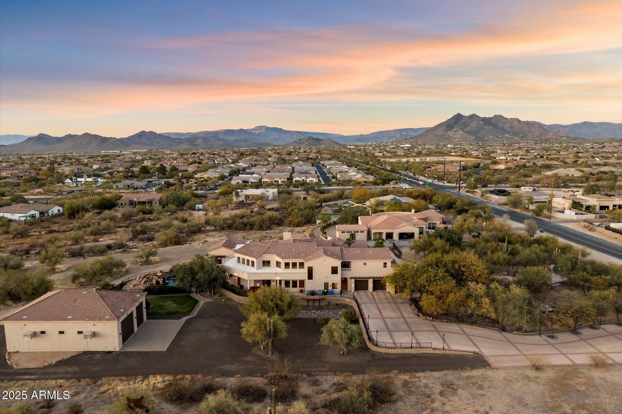 Private 3.4-acre Cave Creek estate with 8,076sq ft of luxury living, self-contained 768sq ft detached guest house, and a 12-car climate-controlled garage—designed to elevate both lifestyle and flexibility. A sweeping 360° circular drive leads to a 2,520 sq ft RV garage with pass-through access, dual cooling, and space for up to 12 vehicles—perfect for exotic cars, off-road toys, lifted trucks, or your full-scale adventure fleet, with room to add a workshop or install car lifts. The garage also includes a half bath and washer/dryer hookup for added convenience. Plenty of slab parking. Inside, the dramatic great room features retractable glass walls unveiling a resort-style pool with grotto, spa, and firepit—framed by unforgettable desert sunsets. Designed with the home chef in mind, the kitchen offers ample prep space and high-performance appliances, and seamless flow to indoor and outdoor dining. Additional highlights include a loft, theater, game lounge, secret room, hobby room, executive office, and a spa-style primary suite with private sitting area, direct patio access, and a luxurious jetted tub for ultimate relaxation. A secondary bedroom suite on the main level also features its own jetted tub ideal for guests seeking comfort and privacy.
Upstairs, two spacious bedrooms share a well-appointed bath with dual vanities and a separate shower for added privacy. Just outside, a hallway snack and coffee station with sink, microwave, and mini fridge offers convenient access to two separate private view decks ideal for quiet mornings or sunset wind-downs.

The detached guest house includes a full kitchen, bath, living area, and stack w/d hookup perfect for long-term guests, multigenerational living, or a serene private retreat. With no HOA, horse privileges, and the peace of wide-open desert surroundings, this one-of-a-kind estate offers freedom, function, and finesse.

Subdivision has CC&R's but no HOA. 
Nestled in the heart of the stunning Sonoran Desert, Cave Creek offers a unique blend of natural beauty, outdoor adventure, and vibrant community life.  Enjoy panoramic views of the colorful sunsets Arizona is known for in your own backyard oasis.