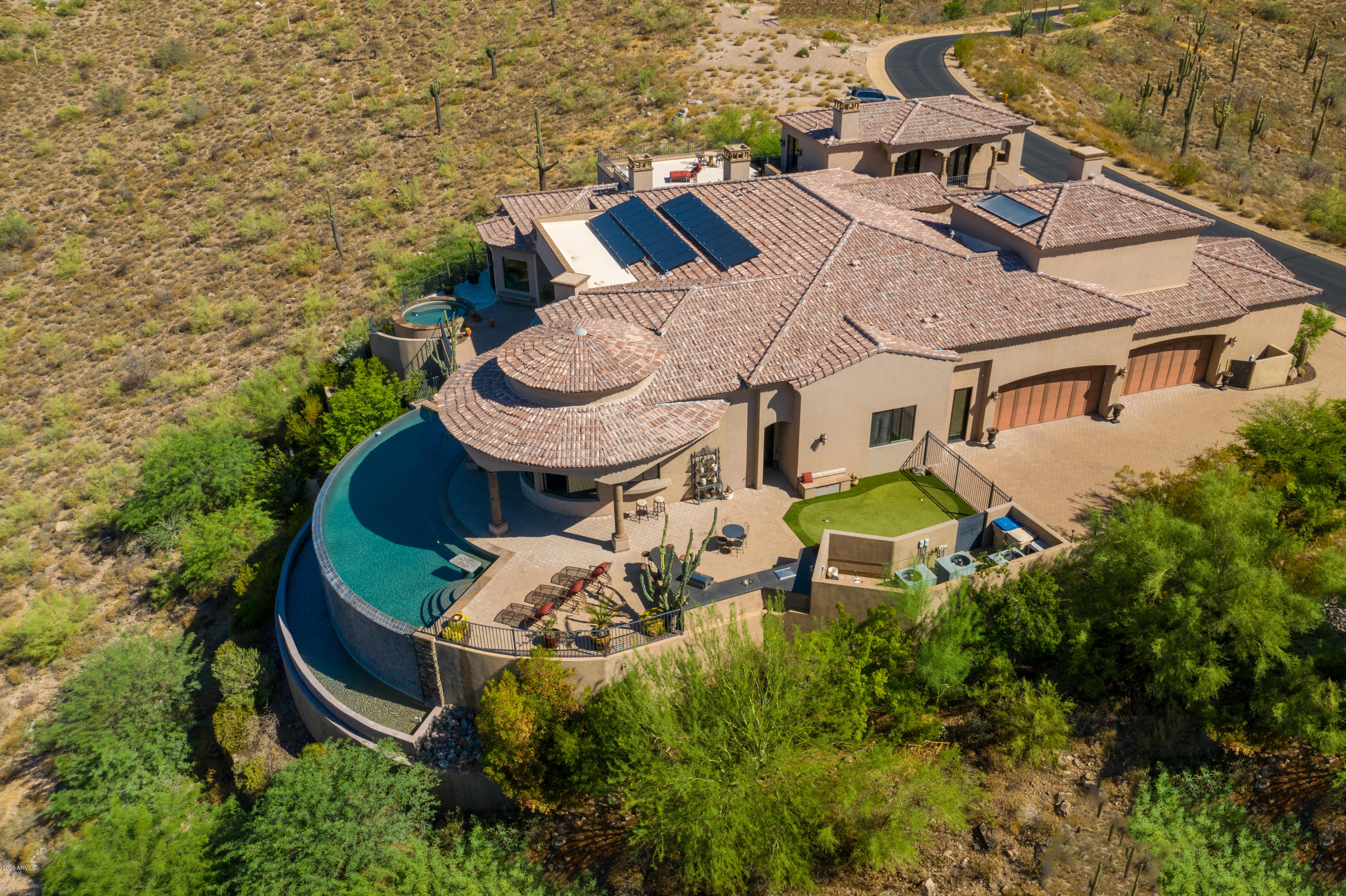 ABSOLUTELY THE MOST AMAZING VIEW IN ALL OF FOUNTAIN HILLS! 360 degree of Breathtaking Views. An atmosphere of tranquility awaits you at this one owner custom home. Timeless architecture & desert living at its best. Details throughout this immaculately maintained estate exude true pride of ownership.gated, 2 acre, mountain top, 8,645 livable sf., 7 bed, 8.5 bath, 7 fireplaces, finished in 2011. There are NO steps anywhere on the approx. 6,000 sf. main level! In fact, there are no steps anywhere from the front drive way to the 60 foot long negative edge pool & spa which are on the main level! Open floor plan.TWO LARGE GUEST HOUSES! 18' retractable wall of glass, 36'' & 24'' travertine. Most bedrooms have solid wood floors, are ensuite, have outside access & lend themselves to guests & more.. Live in~help. Kitchen has 2 of everything, 2 dishwashers, 2 ovens, 2 microwaves etc. Game room, spa/massage room, 6 car garage w/ car lifts! Could be 10 car! Solar power. Don't miss this rare opportunity!

It has forever-unobstructed world class views. The astounding views to the rear are of Camelback Mountain, panoramic city lights, countless other mountain ranges near and far, and the entire world as far as you can see! The views to the front are Four Peaks, the McDowell Mountains, and sweeping city light views all centered on the famous fountain!

Located in the prestigious gated Crestview community of other very large homes, this extremely private and quiet residence is on the very top of the highest mountain ridge in Fountain Hills!

Agents who have seen it say: It has one of the best floor plans in a mountain top home. The floor plan is very open with massive walls of glass to bring the breathtaking views into every room! It is light and bright and extraordinary for living and entertaining. The main areas have huge 36" and 24" imported Italian travertine in the beautiful Versailles pattern. All the secondary bedrooms have solid wood floors. The only room with carpet on the main level is the theater! There have never been any pets in this home, so it may be a great choice for chemical and allergy sensitive people.

The 6,000 sf. main level has a grand foyer with double groin ceilings and a great room, with 18 feet of disappearing glass that automatically retracts into the wall. There is a family room and a bar, both with TV's, and a cliffside circular glass lounge room. WOW! Furthermore, the main level has a dining room with French doors opening to the huge resort~like front court yard and a decked out library/den that also opens to the front court yard. The enormous luxurious master bedroom, on the main level, has the spa right out it's back door, and has one of the best panoramic views imaginable right from your bed! The main level also has 4 bedrooms, 5 1/2 bathrooms, 2 laundry rooms, a unique wine room, and a large media/theater room with a performance area for the kids. The media/theater room has its own bathroom and a huge closet. Adjacent to the media room is a handy door from the house to the back yard, outdoor kitchen and BBQ area. It simply has everything you could dream of.

The dream designer kitchen has a hidden TV and 2 of everything ~ 2 dish washers, 2 ovens, 2 microwaves, and all appliances are hidden as well, which gives it an extraordinary look. The home also has patios and balconies all around the home and off every bedroom, except one. The exterior, and the 7 fireplaces are laden with copious amounts of real cantera.

The versatile floor plan of the house permits wonderful accommodations for your guests and help.

The first guest accommodation has a second huge master bedroom with entry foyer and direct access to the back yard, front of the house, the pool, and by elevator or stairs to the main home. It is immediately adjacent to the game-room, kitchenette, and exercise/massage room. Because of the versatility of this floor plan all these areas can be shared with both the guest accommodations and the main home.

The second is a guest house that has direct access to the main house via an elevator. It also has a cantera staircase down to the front court yard. This guest house is a very private 2 room luxury suite with an entry foyer , bedroom, living room and kitchenette. Furthermore, there are two amazing patios with sweeping mountain and city light views.

The third guest accommodation is an attached casita with kitchenette which is also off the front court yard. This casita would also be perfect as a private office with front entry access through the huge front courtyard. (The den/library in the main home also opens to the front courtyard)

There are also several other large bedrooms that lend themselves to live~in help and guests, as all bedrooms are ensuite, have huge walk in closets, and most open to outside courtyards and have front and back access.

All guest accommodations are without interior steps and with easy access to the main part of the house, the pool and spa, the main patios, the front and back of the house, and the garage.

There is a Spa/massage/exercise room with an earthy stone~laden bathroom and steam shower. (A closet off the hall is pre-wired to be a sauna)

Garage ~ There is an huge oversized, extra high & extra deep 40x23 garage that can park four cars, plus toys. It has 9' tall 18' wide garage doors to accommodate car lifts and long tall boats. There is a small workshop in the garage and also an air conditioned work room inside the house so you can tinker in comfort.

THE 4 CAR GARAGE CAN EASILY BE MADE INTO A 6 OR even 10 CAR GARAGE! ONE OF THE TWO DIFFERENT GUEST CASITA IS RIGHT NEXT TO THE GARAGE. THE WALL BETWEEN THE 365 SF. CASITA AND GARAGE COULD BE REMOVED SO THE CASITA, COULD BECOME TWO MORE BAYS WHILE KEEPING THE BATHROOM & KITCHENETTE TO MAKE A REALLY DECKED OUT GARAGE! FURTHERMORE, PART OR ALL OF THE GARAGE COULD EVEN BE AIR CONDITIONED IF YOU WANTED. YOU WOULD STILL HAVE 3 GUEST ACCOMMODATIONS/HOUSES AND OVER 8,000 SF. OF LIVABLE FOOTAGE. SO, IT DOES NOT DETRACT FROM THE HOUSE TO CONVERT THIS ONE GUEST CASITA TO GARAGE BAYS. ALSO, THE CEILING IS TALL ENOUGH TO ACCOMMODATE CAR LIFTS IN ALL BAYS. THE LADDER YOU SEE IN THE PHOTO GOES TO A 400 SF. TEN FOOT TALL STORAGE ROOM OVER THOSE 2 BAYS. THIS WOULD THEN EQUAL A 10 CAR GARAGE IF YOU WANTED! WOW! ALSO, A THERE IS A VERY FLAT, VERY EASY TO BUILD VACANT LOT NEXT DOOR THAT IS ALSO FOR SALE IF YOU WANTED TO BUY IT AND BUILD YOUR DREAM GARAGE!

Electronics & Furniture ~ The home has a state of the art Crestron media and audio system. Everything is hard wired including the computer network so you don't have to worry about any wireless! Also, all the TV's, stereo equipment, and theater equipment come with the home! There is even a disappearing TV that elevates remotely out of the family room fireplace that is included. In fact, all the furniture is negotiable as well, so you could get this home turn~key with everything you see! (except a few small exclusions)

There is also a 19x22 foot additional room above the garage that is not included in the square footage. It could be an artists studio, collector's room, or a huge storage room. If you want that extra large room for whatever...you've got it! We did not include it in the square footage because it can only be accessed from the garage.

Green and energy efficient features This property was built to be green and energy efficient. The house has solar power, and the main hot water heater is also solar powered. Furthermore, the property has specially placed insulation that increases the energy efficiency. The electric bills for this 8645 livable sf. property are in the $200's, on average. Amazing! Also, it has a "no chemicals added" natural whole house water purification system.

This extraordinary property is on a private Cull de sac that looks like it is on top of the world. The exterior has synthetic stucco for a low maintenance smooth clean look. Just past the outdoor kitchen there is a 15 by 20 foot flat area that is perfect for grass, a putting green, or any thing you want to do with it.

The owners were on site almost every day while the home was under construction making sure this home was built to the highest of standards... and built as you would have wanted.