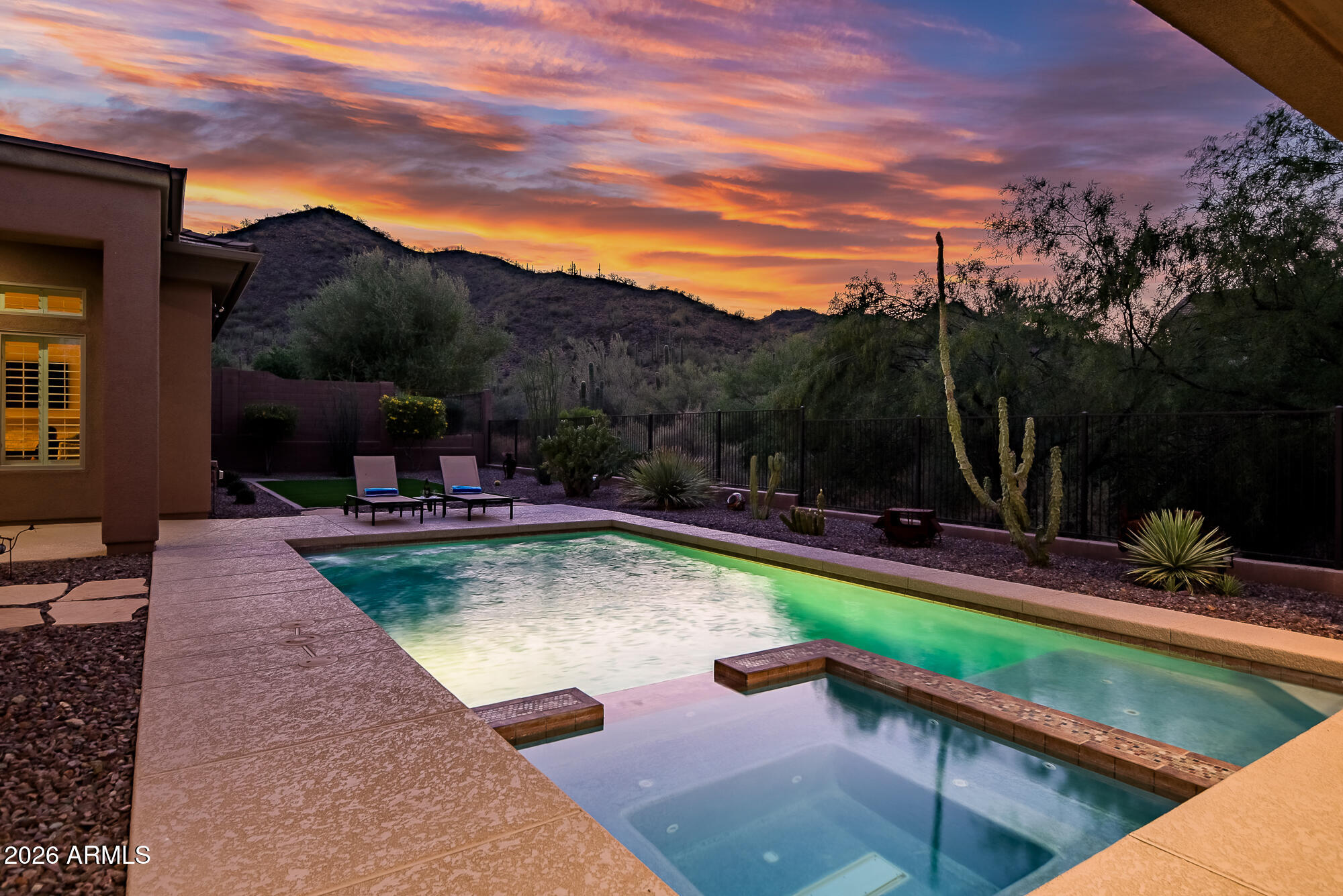 Experience luxury country club living in this exquisite Brentwood model filled with upscale amenities and designer upgrades throughout. Split floor plan with a serene primary retreat featuring a gas fireplace, spa-inspired bath with double-head shower, illuminated mirrors, garden tub, and dual walk-in closets. Gourmet kitchen boasts custom cabinetry, oversized island, pot filler, RO system, Wolf 6-burner double oven gas range, and Sub-Zero refrigerator. Travertine flooring, plantation shutters, custom paint, designer lighting, wood office floors, and elegant media wall with electric fireplace. Resort-style backyard offers pool/spa with Baja shelf, ramada with gas fireplace, putting green, turf, dog run, and breathtaking mountain and wash views. New windows throughout!
