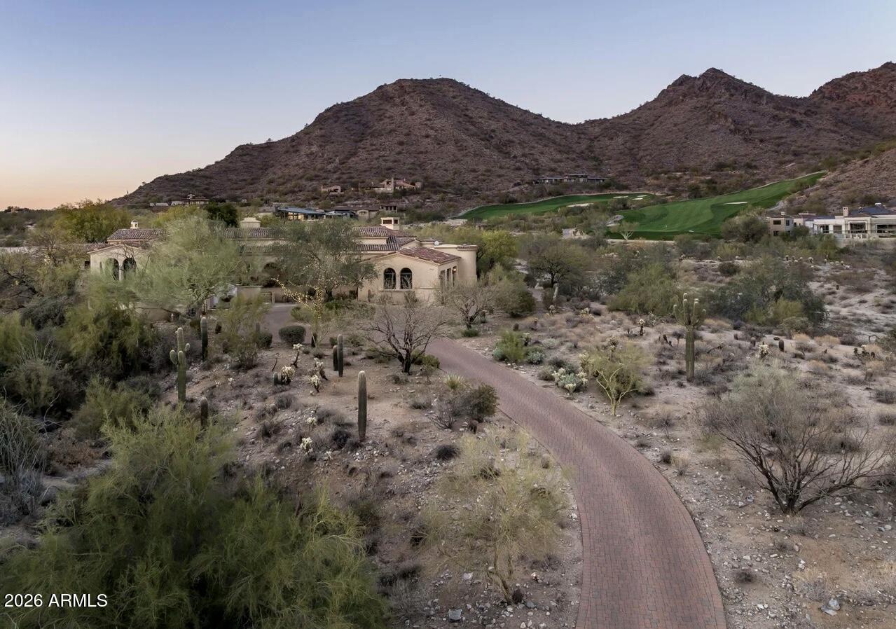 Discover the ultimate in Arizona living with this recently updated hacienda-style home, located on the best canyon lot in the exclusive Country Club at DC Ranch. This stunning custom Spanish home sits on approximately five (5) acres of preserved land and offers a rare combination of breathtaking mountain views, unrivaled privacy, and exceptional craftsmanship. This classic estate feels much bigger than its 6,159 square feet, with an additional 2,200 square feet of outdoor living under roof, affording unobstructed and dramatic canyon views. Inspired by the timeless charm of the Hermosa Inn, this residence offers a resort-like feel, making it the perfect escape from the everyday, like your very own private retreat, with unparalleled seclusion and tranquility. Built by renowned Nance Construction, this home is a true sanctuary, offering an expansive floor plan that seamlessly blends indoor and outdoor living. The primary suite is a standout feature of this home, offering an exceptional layout with a private patio, charming views, and bathroom with "his and her" vanities, closets, and toilets, providing ultimate convenience. Whether you're enjoying the spectacular mountain vistas, relaxing by the pool, or entertaining in the meticulously designed spaces, this home is an oasis that offers the best of Scottsdale living. Indulge in the luxury, privacy, and exclusivity of your own private hacienda where every day feels like a vacation. The build-able site is 1.35 acres, with additional land available to build an expansive guest house or expand the current home. A home in this location rarely comes on the market, you must see it in person to appreciate it.