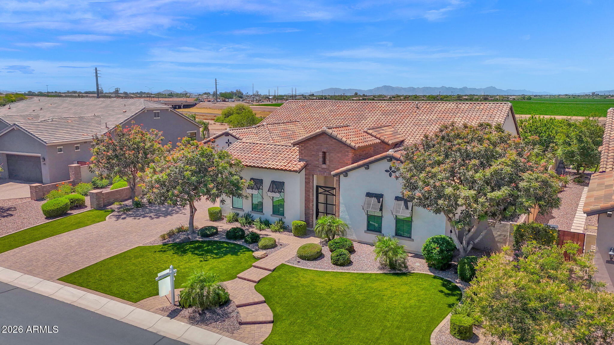 Welcome to a truly exceptional home in the highly sought-after gated community of Calliandra Estates, where luxury, comfort, and thoughtful design come together seamlessly. Situated on one of the largest lots in the neighborhood, this beautiful residence offers an elevated lifestyle with high-end finishes, modern upgrades, and incredible indoor-outdoor living. From the moment you arrive, you're greeted by a stunning custom front door and private courtyard entry, setting the tone for the sophistication found throughout the home. The exterior was freshly painted just two years ago, complementing the meticulously maintained grounds and lush landscaping, including mature fruit trees and low-maintenance turf in the front yard.  Inside, the office and laundry room were remodeled within last two years .  Upgraded lighting throughout and a seamless flow of warm wood flooring--no carpet anywhere except in owner's closet. Large floor-to-ceiling windows in the hallway flood the home with natural light, creating a bright, open atmosphere that highlights every custom detail. The chef's kitchen is nothing short of spectacular, featuring high-end appliances of Wolf and Sub Zero, quartzite countertops, and a unique view window beneath the cabinetry that adds both light and architectural interest (only one in community). Cabinet and island lighting elevate the ambiance, making this space as functional as it is beautiful--perfect for both everyday living and entertaining. The family room is designed for comfort and connection, complete with surround sound for an immersive entertainment experience as well as a sitting area with a fireplace. Throughout the home, you'll find custom touches like designer wallpaper in select rooms and stylish barn doors that add character and charm. A versatile office space offers flexibility for remote work or guests, complete with an automated blind for privacy or natural light. The Murphy bed provides additional functionality, easily transforming the space to meet your needs. The marble counters accent the blue cabinetry perfectly.  Storage is abundant, with all bedrooms featuring walk-in closets, and the garage has been thoughtfully upgraded with built-in cabinets, a utility sink, and durable epoxy flooring--ideal for organization and clean living. Step outside to your private backyard oasis, where every detail has been considered. Enjoy relaxing evenings under the beautifully lit gazebo, while misters keep you cool during warm Arizona days. Adjustable electronic shades provide comfort and shade when desired, making outdoor living enjoyable year-round. Located in the highly desirable Chandler school district.