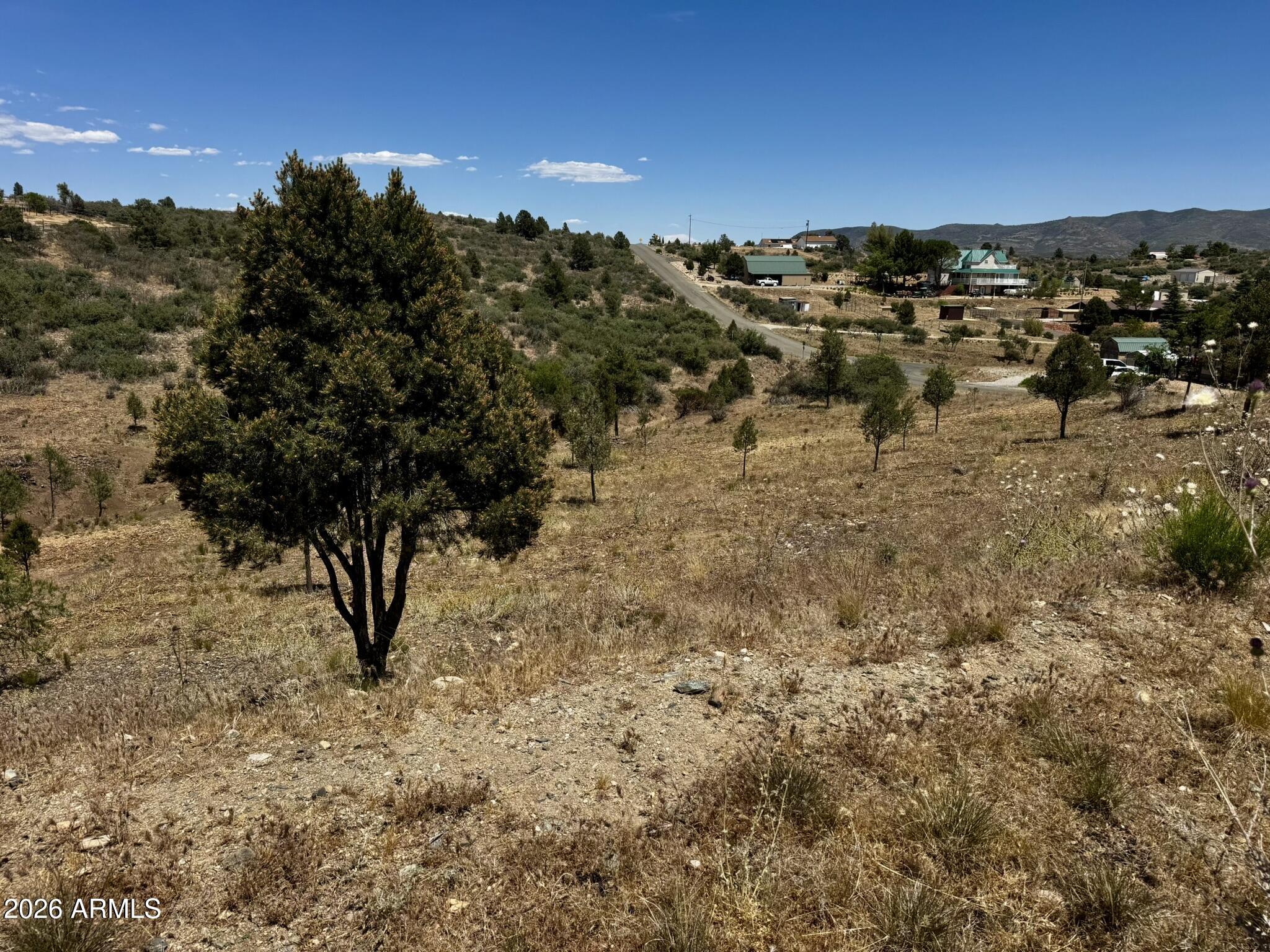 Ready to build and packed with improvements, this beautiful Peeples Valley property offers an incredible opportunity to create your dream home in one of Arizona's most scenic rural communities. Water and electricity have already been brought to the property, a septic tank is installed, and a house pad is in place--saving you time and expense as you begin building. Enjoy breathtaking panoramic views in every direction, wide-open spaces, and the peaceful lifestyle that makes Peeples Valley so desirable. Horses are welcome, and the property's unique layout offers endless possibilities. A seasonal wash traverses the land diagonally, while an additional cleared area on the northeast side provides the perfect location for a workshop, greenhouse, horse facilities, RV storage, or other custom improvements. Conveniently located just a few miles from Highway 89 and accessed by paved roads, this property combines easy year-round access with the privacy and roominess of country living. Site-built homes only, with a minimum 1,500 square foot build requirement. No manufactured homes allowed. Peeples Valley is known for its four mild seasons, blue skies, fresh mountain air, and stunning natural beauty. Outdoor enthusiasts will appreciate the abundant hiking, walking, and wildlife opportunities right outside their door. With an easy commute to Wickenburg, Prescott, and Phoenix, you'll enjoy the perfect balance of rural tranquility and modern convenience.