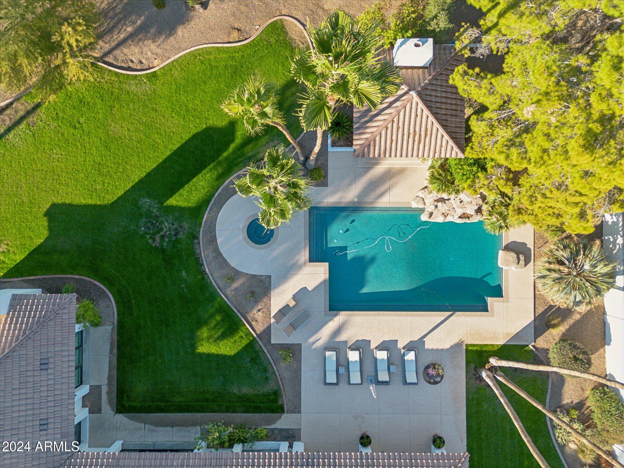 This Paradise Valley home sitting on nearly an acre of land has been remodeled to perfection. Five spacious bedrooms, one sitting privately on the opposite end of the home for a possible nanny or mother-in-law, 4.5 baths, two living areas, massive amounts of storage, and a kitchen of your dreams. As you enter through the charming gate, a delightful front courtyard invites you to have a seat and enjoy the mountain view. Open your front door, and it's immediately clear that this home has a designer's touch with all the elements of today's style and finishes. The warm hardwood flooring and stunning stone fireplace transform the large space into elegant/cozy - and a perfect blend of modern and traditional. The chef's kitchen boasts custom white oak cabinetry, and Dacor range with double ovens Cocktails are served in your sophisticated, fully-equipped wet bar with a Sub-Zero wine fridge. This expansive kitchen space was set up for entertaining. All looking out to the pool with rock waterfall, huge covered patio, and a separate gazebo to sit by the fire. Welcome to your Paradise Valley home in the Scottsdale unified school district with admission to the "3C" schools. You have arrived.
