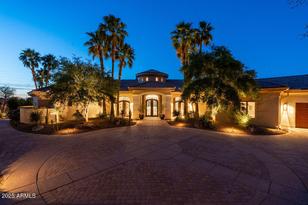 Perched in the heart of Paradise Valley, this stunning single-level estate offers panoramic mountain views that stretch endlessly across the horizon — the perfect backdrop to everyday living or elegant entertaining.
Step inside to a thoughtfully designed layout where refined luxury meets ultimate comfort. The spacious sitting room features a see-through fireplace that warms both the intimate lounge area and The Bourbon-Scotch Bar — a custom-built retreat perfect for evening pours and relaxed conversations.
This home was made for seamless indoor-outdoor living. Open the doors from the family room to a tranquil courtyard with a cozy firepit, the perfect spot to enjoy morning coffee as the Arizona sun rises. Music drifts softly through the entire home, thanks to a built-in sound system that sets the tone for every moment.
The estate includes a beautifully appointed 2-bedroom guest house, each room with its own ensuite bath, plus a full kitchen and laundry  ideal for long-term guests or multigenerational living.
Unwind in the private massage and exercise room, complete with its own entrance and serene courtyard  your personal sanctuary just steps from the main residence.
Storage is no afterthought here. The custom-designed closets include a dedicated washer/dryer and secure safe in her suite, while a spacious laundry room with full-size appliances serves the rest of the home with ease.
Luxury, comfort, and thoughtful design come together in this one-of-a-kind Paradise Valley estate  a place to live, entertain, and truly enjoy the view.