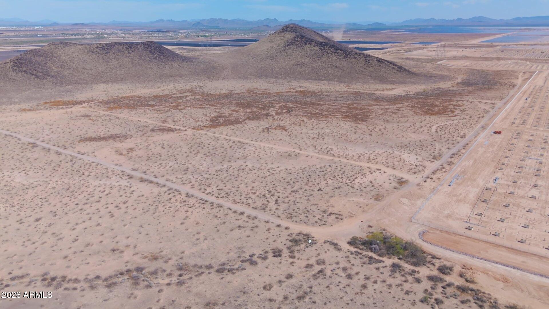 5.02-acre R-43 parcel in Maricopa County, west of Buckeye in the West Valley growth corridor. Flat Sonoran Desert floor with sparse scrub and minimal clearing needed to site a home. Dirt road access along the west and southwest boundary. R-43 (Rural-43) zoning permits rural residential use on a one-acre-minimum lot basis, with room for ancillary agricultural activity such as livestock. No HOA, no CC&Rs -- build timelines, design, and land use stay flexible. 5.02 acres, R-43 (Rural-43) zoning Dirt road access on west/southwest boundary Flat Sonoran Desert terrain, sparse scrub APS electric available; well required (300-600+ ft); standard septic; propane No HOA, no CC&Rs Suitable for an owner-builder homesite, small agricultural use, or long-term hold in a documented growth area.