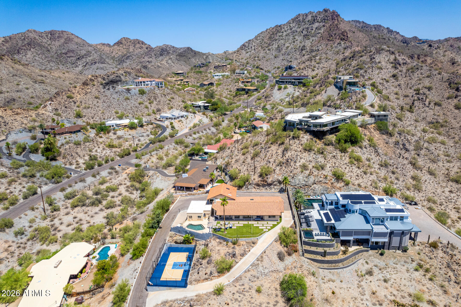 Views for miles! Enjoy breathtaking panoramic views in every direction. Camelback Mountain to the east, Sky Harbor to the south with planes taking off and landing, and downtown city lights to the west. This hillside home offers views unlike anything you've seen. Featuring 4 bedrooms and 5.5 baths, including a full pool bath. Relax in the pool overlooking the entire city or unwind on the patio where you can enjoy both sunrise and sunset. Rarely does a hillside property offer such a flat pad, easy driveway, and a full sport court with lighting for day or night play. Private primary suite occupies its own level and showcases some of the home's best views, even from the primary shower. Three generously sized secondary bedrooms, two en-suite. 4 car garage & endless options to re-imagine this property. Unbeatable location just minutes from the 51, freeway, world-class shopping at the Arizona Biltmore, golf, hiking, and top-tier dining. A must see!