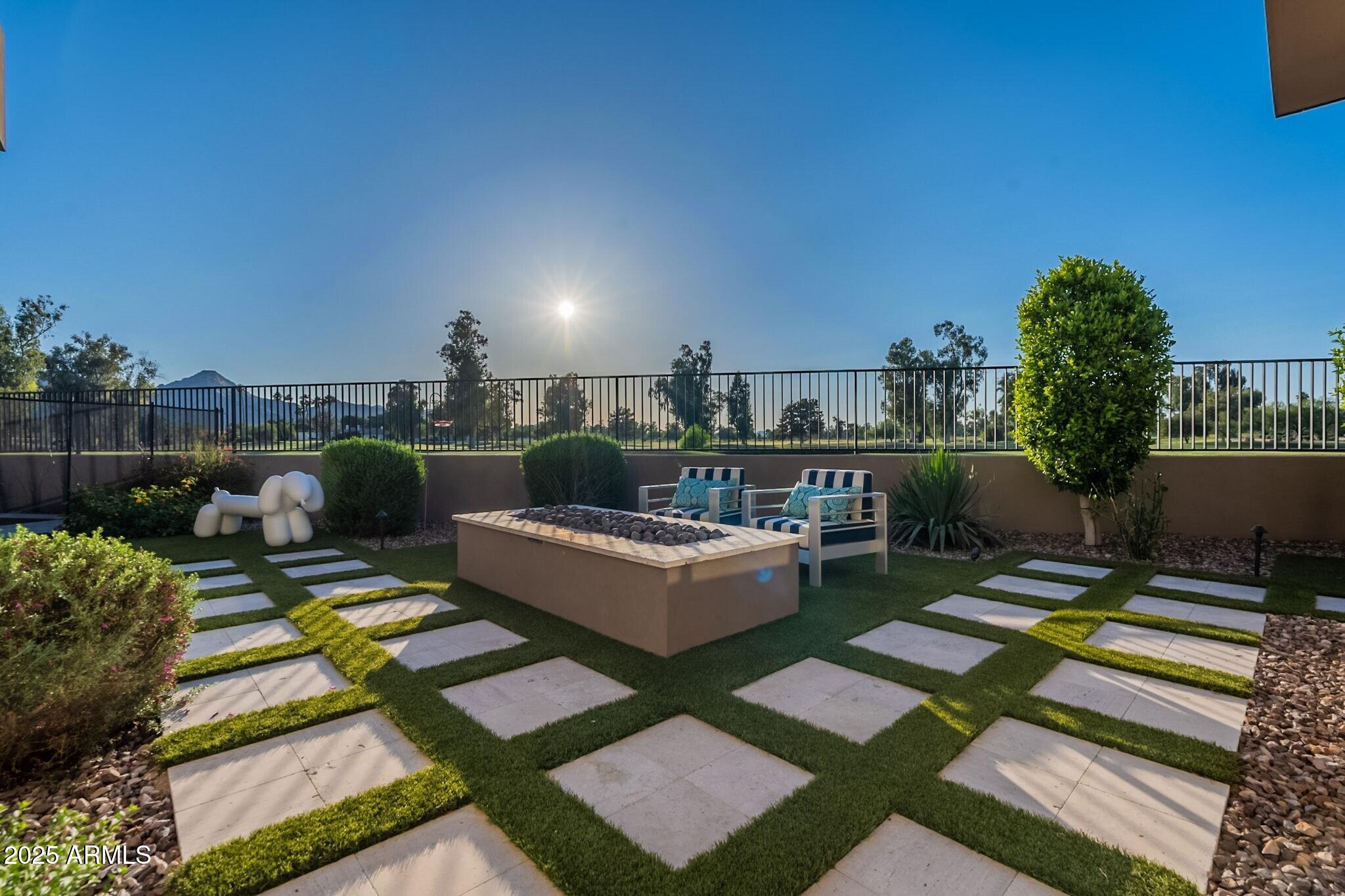 Welcome to this exquisitely customized home, built by the renowned Cullum Homes, within the exclusive gated community of Ironwood Golf Villas—an enclave of just eight custom residences. Offering a rare blend of privacy, contemporary design, and high-end finishes, this home is perfectly situated with stunning views of the Camelback Golf Club and the surrounding mountains. Step through the tranquil front courtyard and enter through a dramatic floor-to-ceiling glass door into an open, light-filled floor plan. The spacious great room features a sleek built-in fireplace and expansive pocket doors that seamlessly connect to the covered patio, creating the ideal indoor-outdoor living experience. A formal dining area sits adjacent, perfect for entertaining. The chef's kitchen is outfitted with premium stainless steel appliances, including a Sub-Zero side-by-side refrigerator/freezer, an 8-burner Wolf gas range with chimney hood, an Asko dishwasher, and custom cabinetry. Additional features include a generous kitchen island, eat-at bar, and a hidden walk-in pantry. Entertainment and lifestyle amenities abound, including a state-of-the-art, stylish and comfortable theater room, a private gym with scenic views, and a beautifully designed powder room. A private casita located just off the entrance serves perfectly as a guest suite, home office, or den. The luxurious primary suite offers direct access to patio and boasts a spacious, fully customized walk-in closet with an island. The spa-inspired ensuite bathroom features dual vanities, a dedicated makeup vanity, a freestanding soaking tub, and a stepless walk-in steam shower with a rain showerhead and two separate water closets. For added convenience, the primary suite includes direct access to the laundry room. Both guest bedrooms feature ensuite bathrooms, providing comfort and privacy for family and visitors alike.
Outside, the covered patio is an entertainer's dream, complete with ceiling fans, built-in heaters, a fireplace, and an outdoor kitchen with a built-in BBQ and sink. Enjoy a dip in the sparkling pool, rinse off in the outdoor shower next to the poolside bathroom. Additional outdoor spaces include a dining area, a cozy fire pit lounge, and a beautifully landscaped yard with unobstructed golf course and mountain views. The private patio off the primary suite offers a front-row seat to the serene surroundings. The four-car garage features built-in storage and room for your gear or workshop needs. Located just minutes from Old Town Scottsdale, Paradise Valley, and Fashion Square, this home offers the best of both luxury and convenience, close to premier shopping, dining, and entertainment.