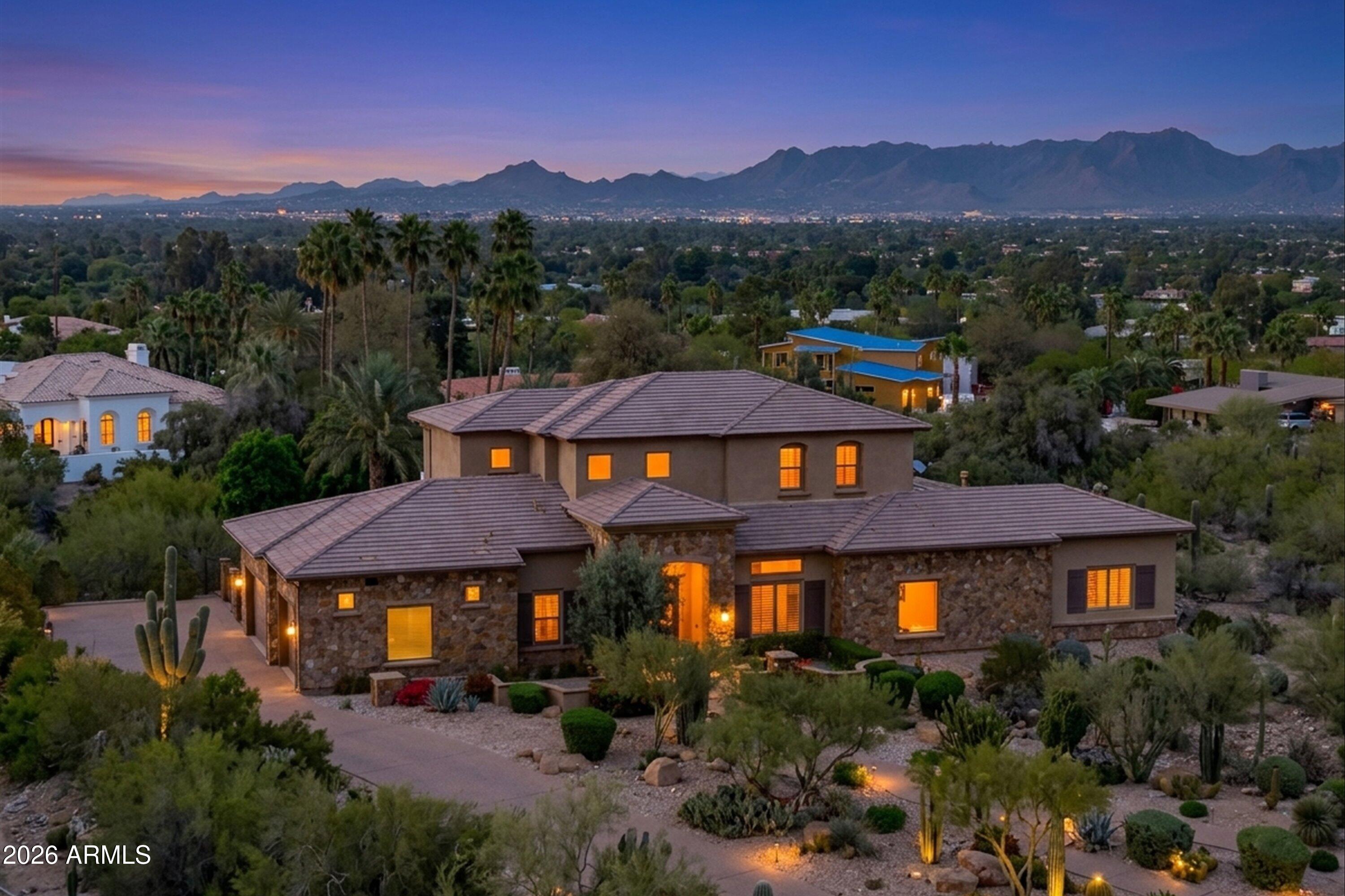 Privately set behind a lush acre of mature botanical-desert landscaping, this elegant Paradise Valley residence offers the ambiance of a secluded retreat. Guests are welcomed through curated desert gardens into a dramatic foyer with an architectural picture window that frames the surrounding greenery. The warm, upscale kitchen flows seamlessly into the inviting family room -- the true heart of the home -- where expansive sliding glass doors open to mountain vistas and shimmering city lights. The serene main-level primary suite provides generous storage, dual walk-in closets, and a spacious bath designed for comfort and ease. Upstairs, two en-suite bedrooms and a welcoming loft with wet bar create an ideal guest retreat. This home is a perfect way to enjoy Paradise Valley living. HIGHLIGHTS
- Located in prestigious Paradise Valley on a full acre of lush, Botanical-Desert landscaping.
- Mountain views by day and sparkling city lights by night.
- Primary living is all on main level with 12' tray ceilings. Guest suites, loft with wet bar and large view deck upstairs.
- Spacious Family room includes, Fireplace and 16' sliding glass doors showcasing mountain and city-light views
- Exceptional privacy and curb appeal
- Built in 2018, offering newer construction, updated systems.

KITCHEN:
- Upscale kitchen with two large islands, Bosch appliances, and abundant custom soft-close cabinetry.
- Kitchen opens seamlessly to the inviting family room -- the heart of the home
- Walk-in Pantry, Two Ovens, Large Refrigerator/Freezer (New)

MASTER BATH:
- Separate his-and-hers walk-in closets provide generous and private dressing spaces.
- Spacious primary bath with ample cabinetry and storage

OTHER FEATURES:
- Upper-level loft with wet bar, ideal for entertaining or relaxing retreat
- Temperature controlled, oversized 3 car 
- Temperature controlled wine room
- Two upstairs en-suite bedrooms, perfect for family or guests
- Whole house Kinetico Water system - Chlorine Free
- Control 4 (Smart Home/ Automation)
- HVAC Twin Trane Variable speed XV20i
- Automatic whole house water shut-off
- Rare opportunity combining privacy, character, acreage, and views
- Access to Phoenix mountain preserve with hiking trails
