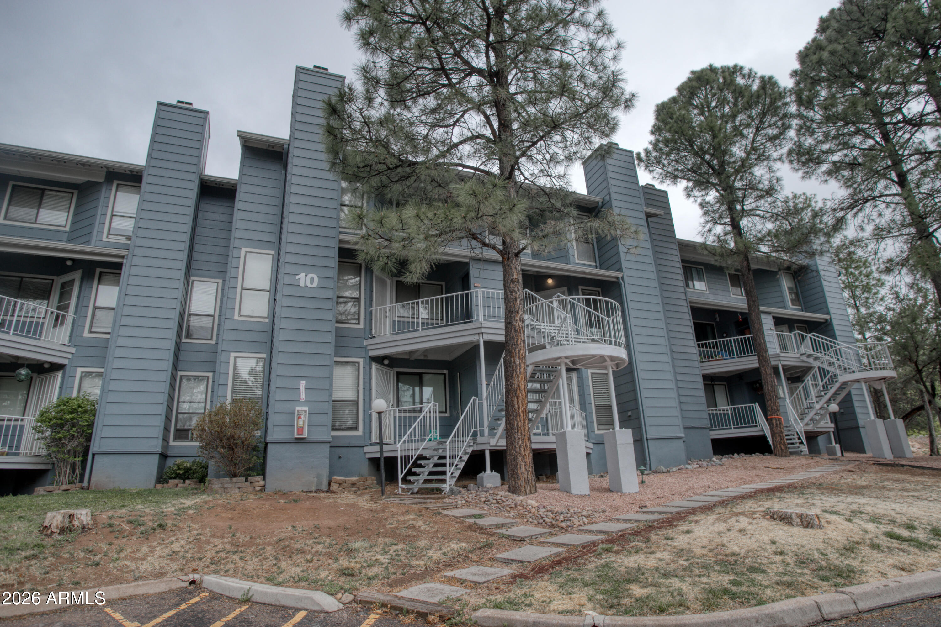 Escape the summer heat in this sweet 2 bedroom 2 bath condo in the tall pines that features a great room living area - increasing social interaction while conveying a sense of calm - as well as a fireplace w/a lovely wood mantel for a focal point! It's turn-key ready with fresh paint & new flooring, with a vaulted ceiling that imparts a feeling of spaciousness & enhances natural light. On the main level there's a bedroom & full bath, with a roomy loft-style 2nd bedroom with en-suite bath just up the spiral staircase. Included in the monthly dues are water, sewer, trash, and exterior maintenance, making either year-round, seasonal living, or renting easy & worry-free! Nicely maintained clubhouse has mail boxes, gas grill, & laundry area, as well as meeting/special events space & seating.