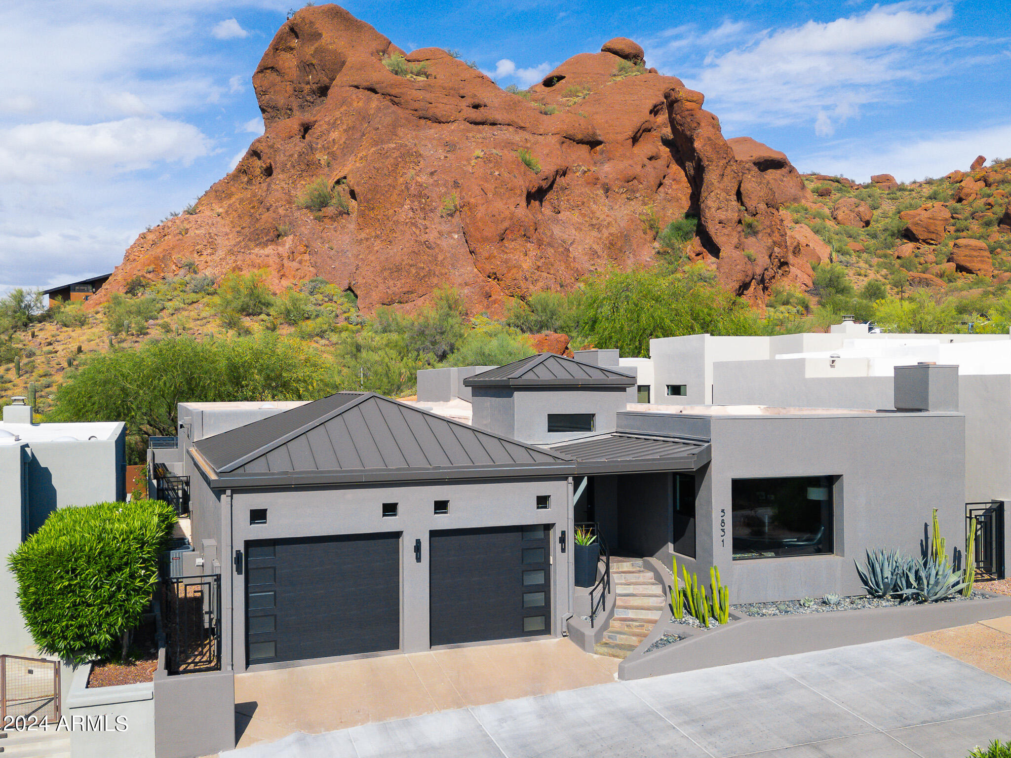 Welcome to Echo Canyon's guard-gated community! This modernly remodeled home offers breathtaking views of Echo Canyon & The Praying Monk. Upon entry, you're welcomed by an expansive great room w/ soaring ceilings. The gourmet kitchen features a stunning prep island adorned w/ a Dekton Trilium countertop. The primary suite is luminous, highlighting views of the Praying Monk & providing private access to the tranquil backyard. Its spa-like bathroom showcases a custom metal barn door, a floating vanity w/ double glass sinks, & Grohe fixtures. Outside, an outdoor kitchen equipped with a 50'' Wolf Professional Gas BBQ & seating area awaits, alongside two custom-designed Eurocave wine coolers holding 500 bottles! A separate den(or potential 3rd bedroom) with fireplace & built in Murphy Bed.... The community also features private hiking trails, pool, spa & tennis.