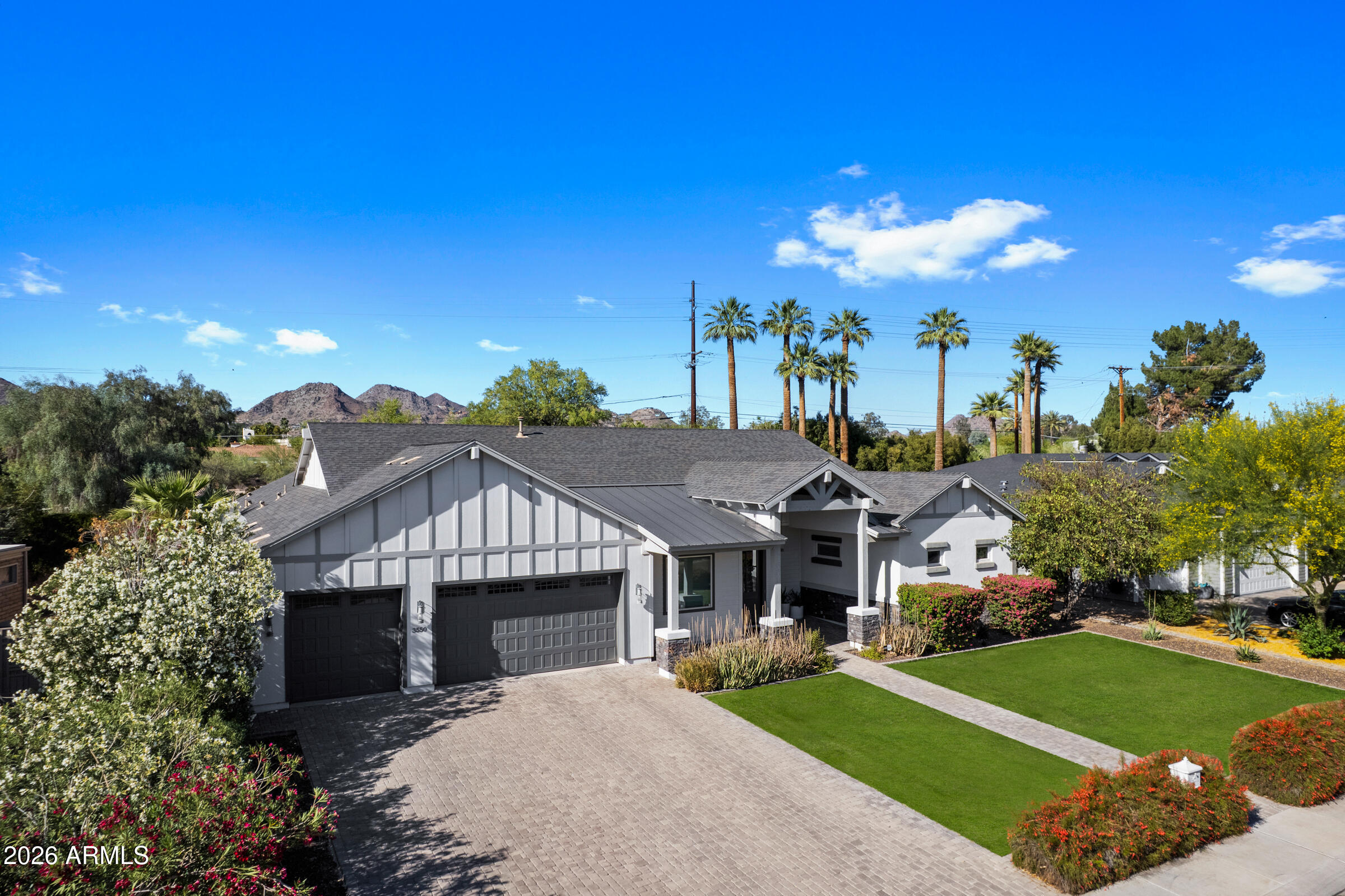 Best of Biltmore Luxury Home Tour Winner -A rare opportunity to own one of the most admired homes currently available in the Biltmore area! Perfectly positioned in the highly sought-after Biltmore Heights subdivision, this exceptional residence offers a rare opportunity to have your backyard back up to the canal, creating a unique blend of privacy, scenic views, and effortless access to one of the area's most desirable outdoor amenities, all set against the backdrop of stunning Piestewa Peak mountain views. This exceptional home masterfully blends timeless elegance with modern sophistication, set on a lush, privately situated lot with meticulously manicured landscaping. Designed to impress, the home showcases soaring ceilings with skylights, hardwood flooring, and a seamless open-concept At the heart of the home, the gourmet kitchen is a true statement, featuring custom cabinetry, dual oversized islands, premium appliances, and an expansive layout that flows seamlessly into the living and dining spaces. A striking indoor-outdoor fireplace anchors the main living area, creating a dramatic focal point that can be enjoyed from both inside and out. The primary suite is a true showpiece, designed as a private retreat with a dream-worthy, boutique-style closet. Every element has been carefully curated to balance comfort, function, and elevated design. The thoughtfully designed split floor plan offers spacious bedrooms, including a private en-suite, a dedicated office, and a versatile game and entertainment room. The game room is enhanced by custom sliding glass doors that fully tuck into the wall, delivering a true indoor-outdoor experience and unmatched flexibility for entertaining. Additional features include an oversized laundry room, a mudroom, abundant storage throughout, and a three-car garage, offering both convenience and everyday livability without compromising style. Step outside to your resort-style backyard oasis, complete with a sparkling pool, misting system, and lush, expansive grounds designed for both relaxation and unforgettable entertaining.