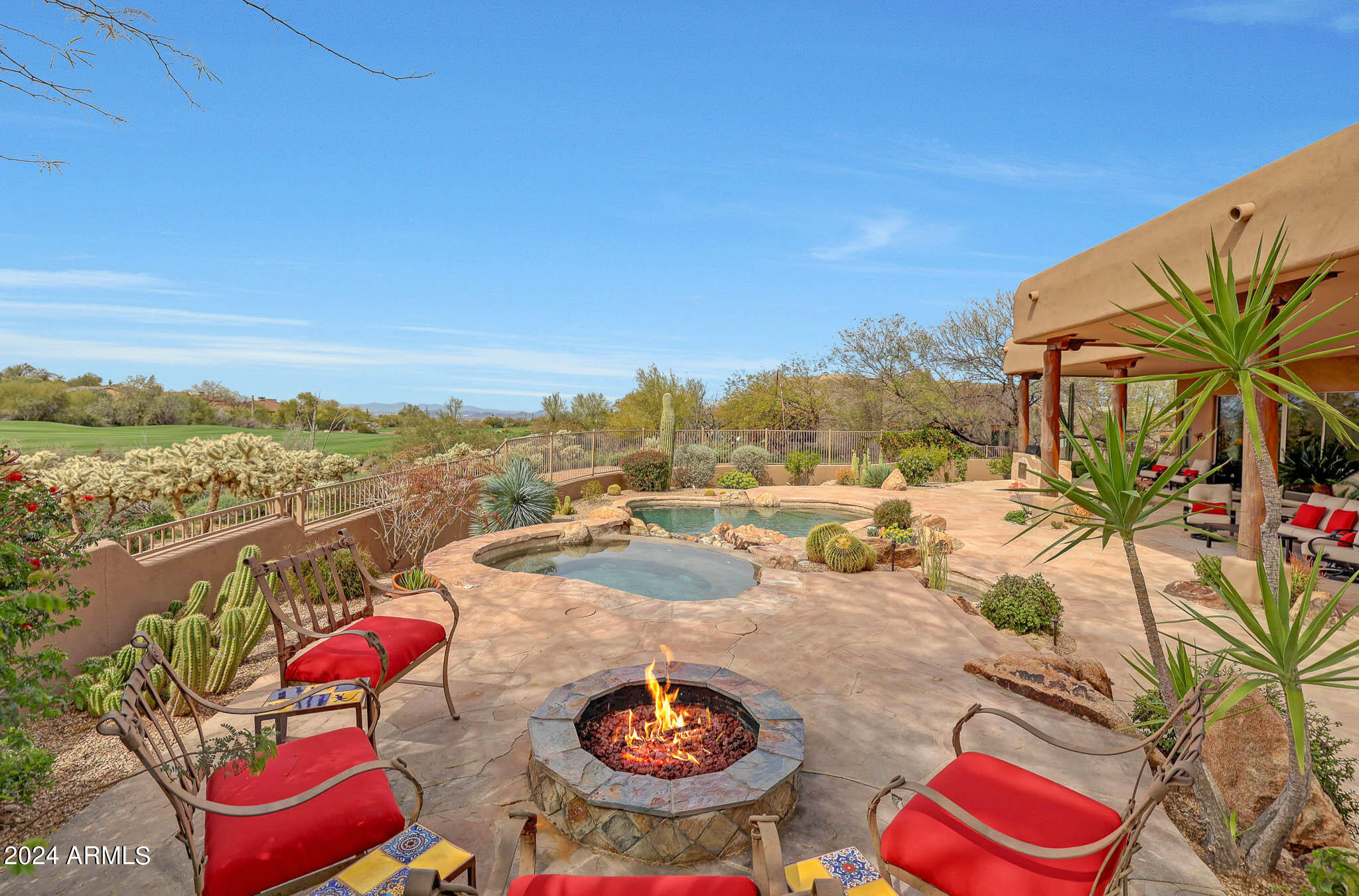 Located in the gated community of Pinnacle Canyon at Troon North, this stunning custom Southwest-inspired estate offers an unparalleled living experience. Situated along the 17th fairway of the Monument course at Troon North Golf Club, the residence boasts breathtaking panoramic views of the golf course, Pinnacle Peak, and captivating sunsets, along with sparkling city lights. Spanning across the landscaped grounds, the property features amenities designed for luxurious living and entertaining. The property comes fully furnished, including all accessories, included in the asking price.
As soon as you step inside take note of the direct view of Pinnacle Peak. No interior steps on the main level. With four spacious bedrooms, each accompanied by en suite baths, along with an additional den/office and two powder baths, this home provides ample space and privacy for residents and guests alike. The upstairs bedroom suite is perfect for visiting guests as it offers its own kitchenette, private balcony, and privacy. The interior showcases meticulous attention to detail, with custom features throughout including slate stone floors and details, curved accents and beamed and latilla wood accents. 
A gourmet kitchen, open to a cozy breakfast nook and a stylish family room, serves as the heart of the home, while a separate formal dining room with a two-way fireplace adds an element of elegance. The kitchen boasts new top-of-the-line appliances, including Viking and Wolf, while the great room features a built-in TV niche and a whole-house music system, creating an immersive entertainment experience. Custom cabinetry, granite counters, a gas cooktop, a center island with bar seating, a walk-in pantry, and beamed ceiling details are just some of the features in the chef-inspired kitchen. 
Step outside to discover a backyard oasis complete with southern exposure, a heated pool, spa, cascading waterfall, fire pit, and a built-in BBQ area, perfect for outdoor entertaining and relaxation. The landscaping has been meticulously maintained, with irrigation systems updated, and low-voltage lighting systems enhanced for ambiance. Additionally, the home has undergone extensive upgrades, from new dimmable LED lighting fixtures to fresh paint both inside and out.
The formal living room, also graced by a fireplace and a wet bar, offers a refined space for gatherings. Throughout the home, fireplaces have been refinished and equipped with remote starters, and lighting systems have been upgraded for added convenience. Additional upgrades include new water heaters, new outlets and wall switches throughout, new lighting accents and fans, and a new central vacuum system.