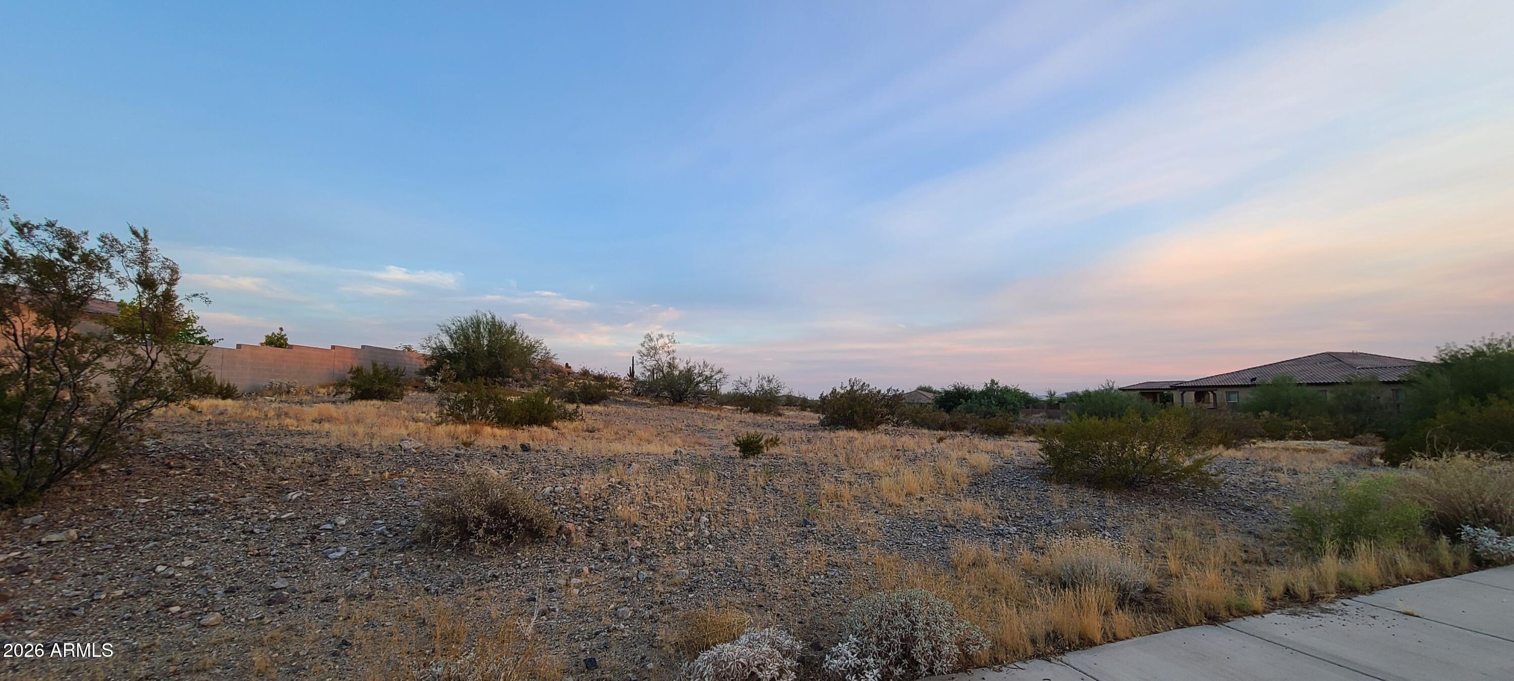 Perched on one of the higher elevations in gated Ventana Picachos (Vista Montana), this 1.08-acre homesite sits high enough to capture sweeping valley views -- with the right design, an elevated or multi-level build can frame panoramic city-light and mountain vistas lower lots can't reach. It's also build-ready: unlike most acre lots here, it's on PUBLIC SEWER with water, gas (SW Gas), electric (APS), cable, and phone all stubbed to the property -- no well to drill, no septic to install. A platted subdivision with paved access behind a private gated entrance, surrounded by custom multi-million-dollar homes, minutes from Lake Pleasant, Four Corners shopping and dining, top schools, and the Loop 101 and 303. Bring your builder and design around the view.