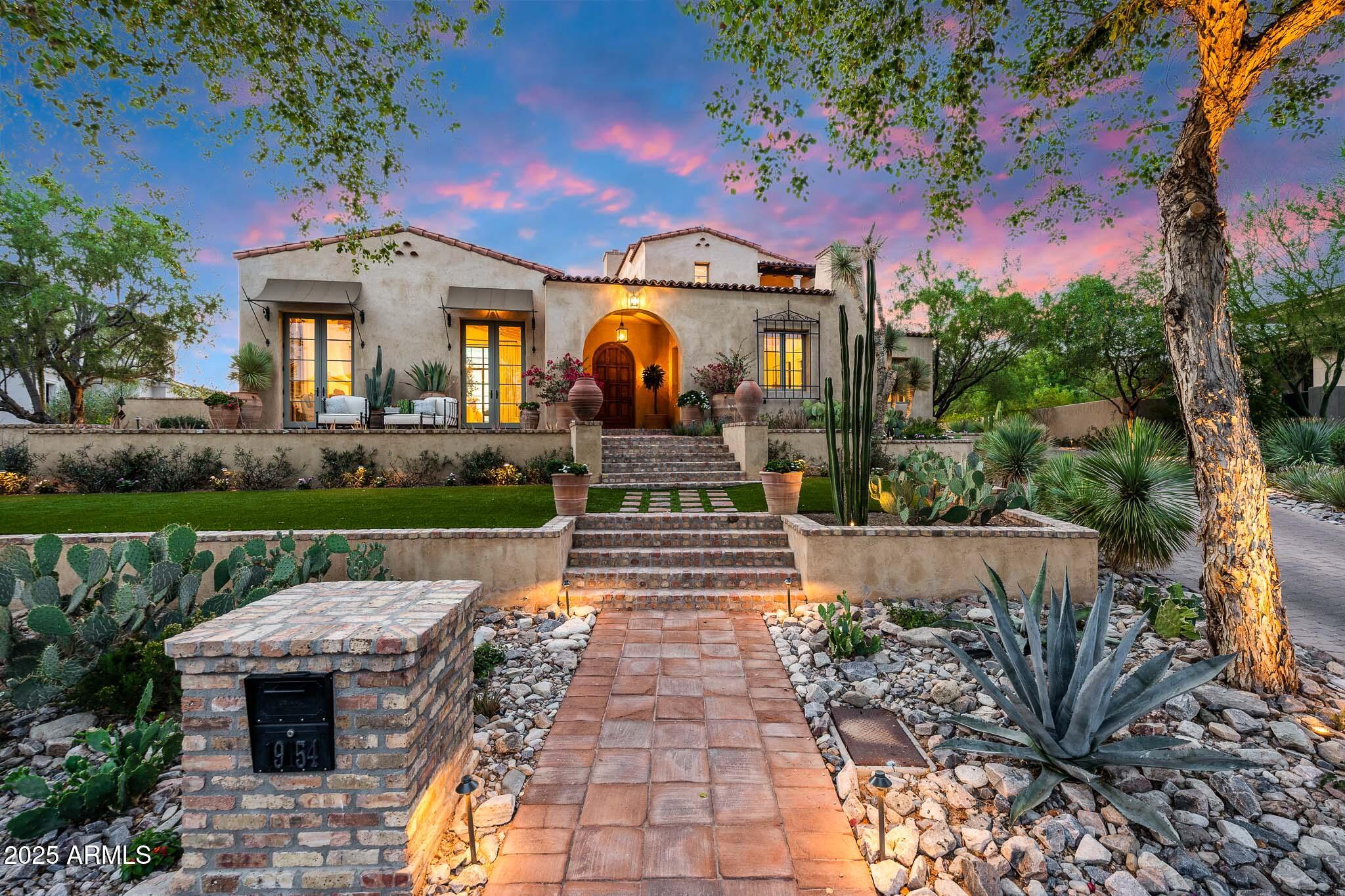 Nestled in the coveted Arcadia neighborhood of Silverleaf, this prime lot backing to the Reata Wash features a truly spectacular custom built estate with a spacious 6,110 Sq Ft floorplan, 4BR's, 4.5BA's & a 3Car Garage with a built-in shop-vac.  The 4th BR is currently being used as a music/bonus room that is only accessed from pool area that could also be used as a separate guest quarters. This gorgeous estate was designed by renowned architect Gene Knaiz of the Spiral Group and built by renowned builder Eric Linthicum of Linthicum Custom Builders. With its hand-made roof tiles, rustic brick, and exquisite stucco exterior - featuring three-coat plaster, this estate exudes a blend of craftsmanship and old-world charm. Inside, accentuated by the white oak floors and beam ceilings, the large, glazed windows flood the living spaces with natural light, creating a tranquil and airy ambiance. The formal living area features a large stunning fireplace, while a separate formal dining room provides an elegant setting for special occasions. The heart of the home, the large dine-in kitchen offers an incredibly spacious kitchen island with breakfast bar, professional-grade appliances... including double Subzero refrigerators with large middle wine fridge, Wolf 60" 6-burner stove with griddle area & double FULL sized ovens, 2 Miele dishwashers, beautiful Subway tile backsplash - from counters to ceiling, and stunningly elegant leathered granite countertops. A generously sized butler's pantry, complete with a refrigerator, dishwasher and separate ice maker, adds convenience to your daily life. The exquisite MBR suite with a dual-access closet, large inviting rain shower & separate soak tub, opens to a private courtyard & separate Zen Garden area, creating a spa-like retreat with an indoor-outdoor patio that features an outdoor shower & wooden view doors that can be opened to the breathtaking Reata Wash for spectacular views. The timeless design elements throughout this home ensure your comfort and style. Outside, landscape architect Steve Martino has created a truly lush and romantic resort-style oasis. A heated pool & spa, along with an outdoor kitchen equipped with a BBQ grill, refrigerator and sink, ensure a perfect outdoor entertainment space. Both the front and back yards feature low-maintenance artificial grass. This estate also features a long private pavered driveway, brick patios and walk-ways, upside down Saltillo tile pool deck and patios, automated sun shade, outdoor gazebo dining area with large fireplace, 3 tankless instant hot water heaters and an impressive updated Savant complete home system with receiver & remotes.  Backing to the gorgeous Reata Wash this serene estate offers privacy and a sophisticated understated luxury that harmoniously blends old-world charm with modern amenities.