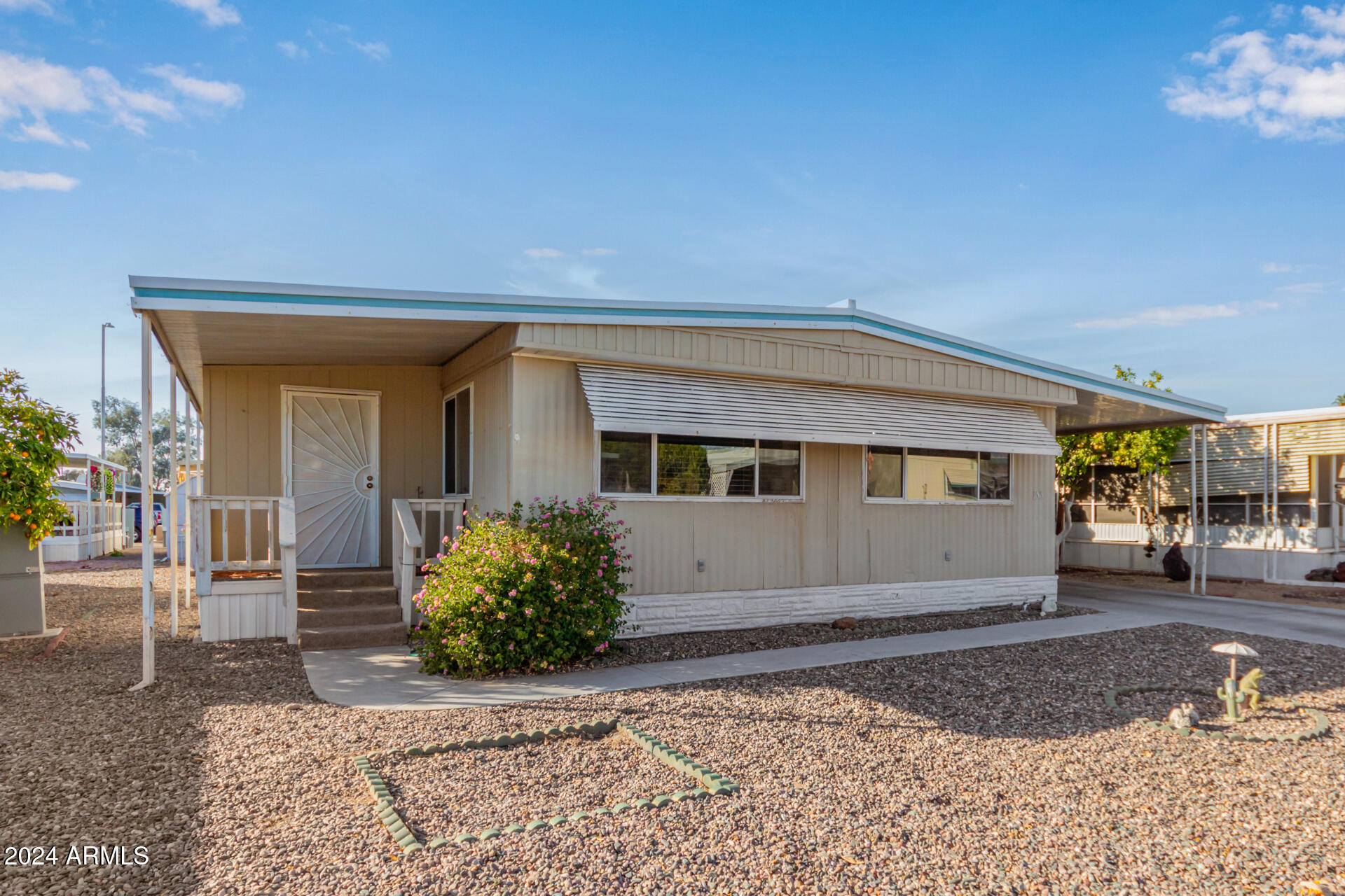 Double wide mobile home nestled in the Gated 55+ Community of Friendly Village of Orangewood! New roof. AC/heating and water heater maintained by Goettl regularly and have supporting documentation. This multi-wide gem offers a great room with built-in china cabinets in the dining area. The kitchen showcases ample counters, a pantry, plenty of cabinets, and built-in appliances for all your cooking needs. Spacious main bedroom and a private bathroom for added comfort. Both bedrooms are carpeted and include their own walk-in closets. Outside, relax under the covered deck while enjoying your favorite beverage. Unit also includes attached storage housing washer and dryer which are included. Community amenities are a clubhouse, pool, spa, gym, and more. You won't be disappointed!