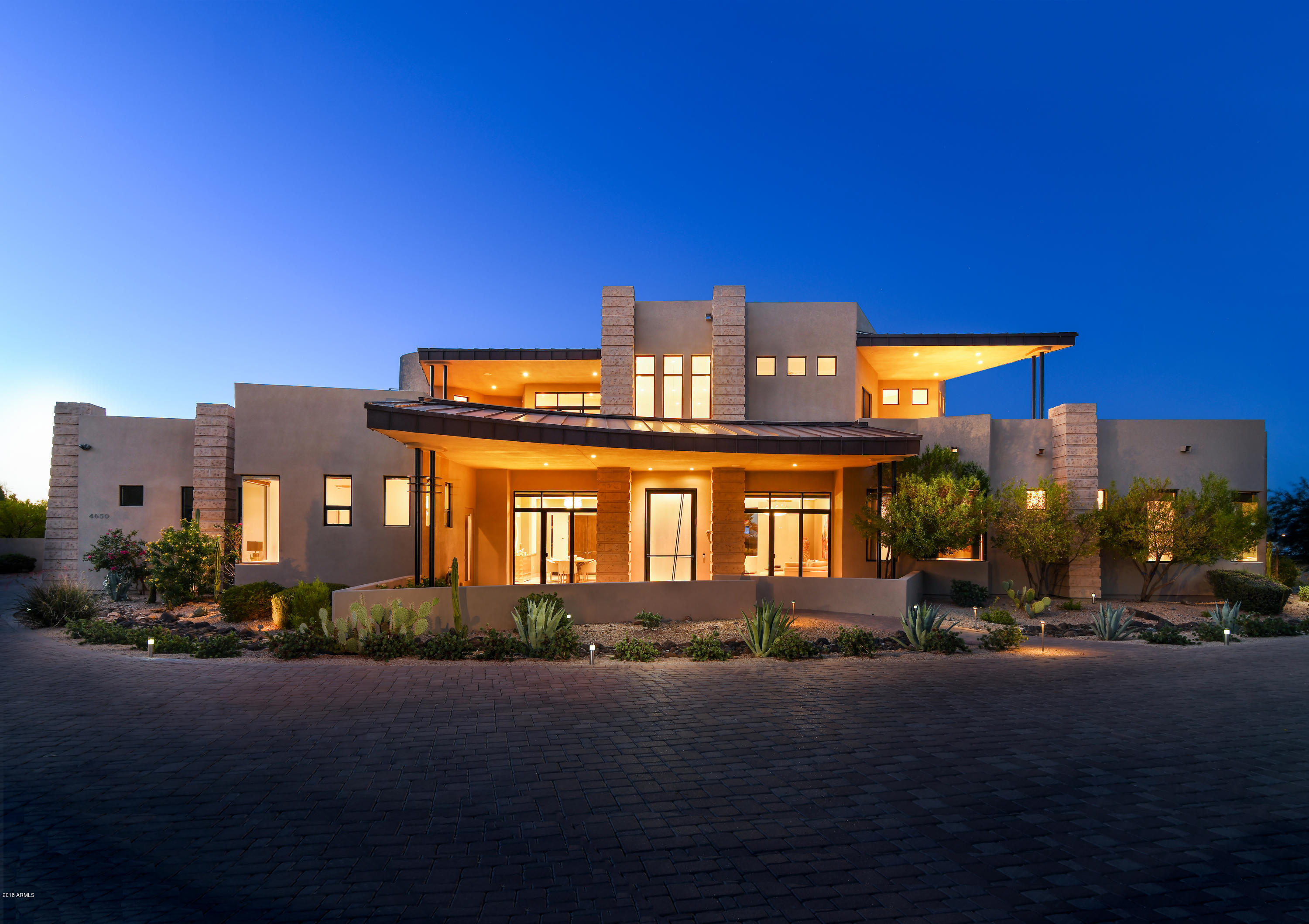 Panoramic City Lights & Towering Mountain VIEWS on all sides of this unique contemporary home situated on a flat, acre lot, built with special permission to 30' tall. Very Private while still taking full advantage of views to four mountain ranges & City Lights, some ceiling heights soaring as tall as 26'. The main floor has 5 en suite bedrooms + all the main living spaces & fantastic sight-lines with open-concept living. The upper floor has 1 en suite bedroom + a gym, a large screening room, & 4 stunning view patios. As a bonus, a rare third-floor patio provides permanent views to The Valley's iconic Four Peaks Mtn Range over 100 mi NE of the home! Sure to impress you with beautifully sourced, timeless finishes,  state-of-the-art conveniences, and unique flair, make sure to visit soon!! The home is completely turnkey having been incredibly maintained, and is certified as a SMARTÂ® home, many of it's features being operated by the owner's phone from anywhere in the world. Fantastic levels of detail in each finish selection, including Fentini fixtures, multiple Swarovski crystal chandeliers, fine french fabrics, and imported wall coverings perpetuate the home's consistent sense of style and quality. Serving as a perfect example of Tsontakis's award-winning design - a measure of harmony, and the sophistication of simplicity - this timeless contemporary delivers on style and design like no other home available.