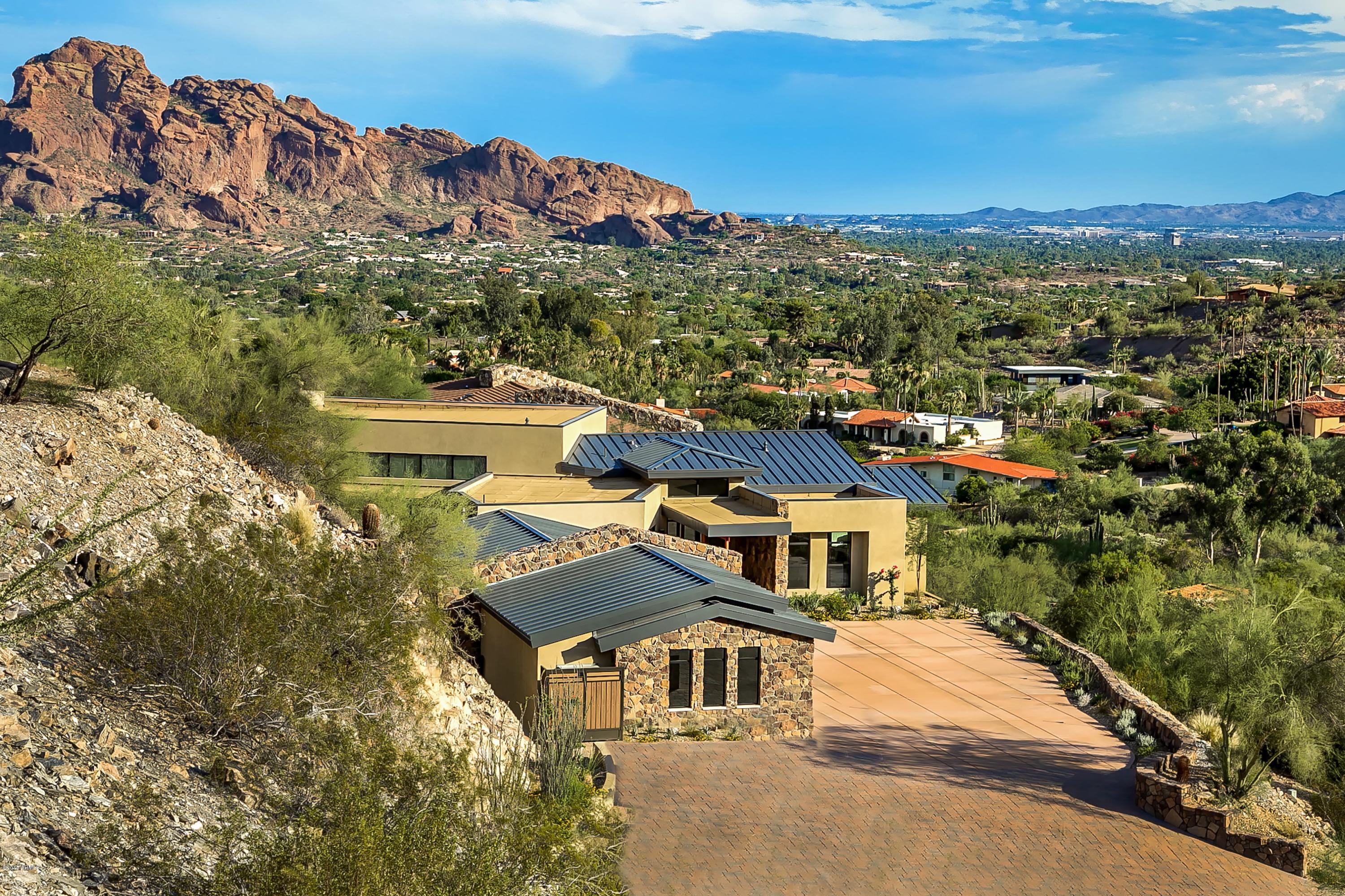 Stunning brand new construction in Clearwater Hills. Home is perched high on the hill with views of Camelback Mountain which allows for beautiful views both day and night. This contemporary home boasts solid walnut 8’ doors with brushed aluminum inlays, custom walnut cabinets throughout, custom stonework inside and out, Brazilian teak ceiling accents inside and out and a metal roof. The bright open kitchen features quartz counter-tops, Custom tile back splashes, Thermador stainless appliances with a d6 burner gas range and warming drawer. The great room opens on both sides with automated pocketing doors to both the interior courtyard and negative edge pool and views. The private master bedroom and bath have butted glass allowing you to take in the view from every location. The pool area overlooks the city light views with a negative edge pool & spa, built in BBQ with an artificial grass sitting area and glass observation wall. The 4 car garage allows you the space you need with extra storage as well. Home was built with efficiency at the for front with foam insulation in the wall & ceilings, 16 seer HVAC units, 2 tankless water heaters with recirculating pumps & LED lighting. You will not be disappointed.