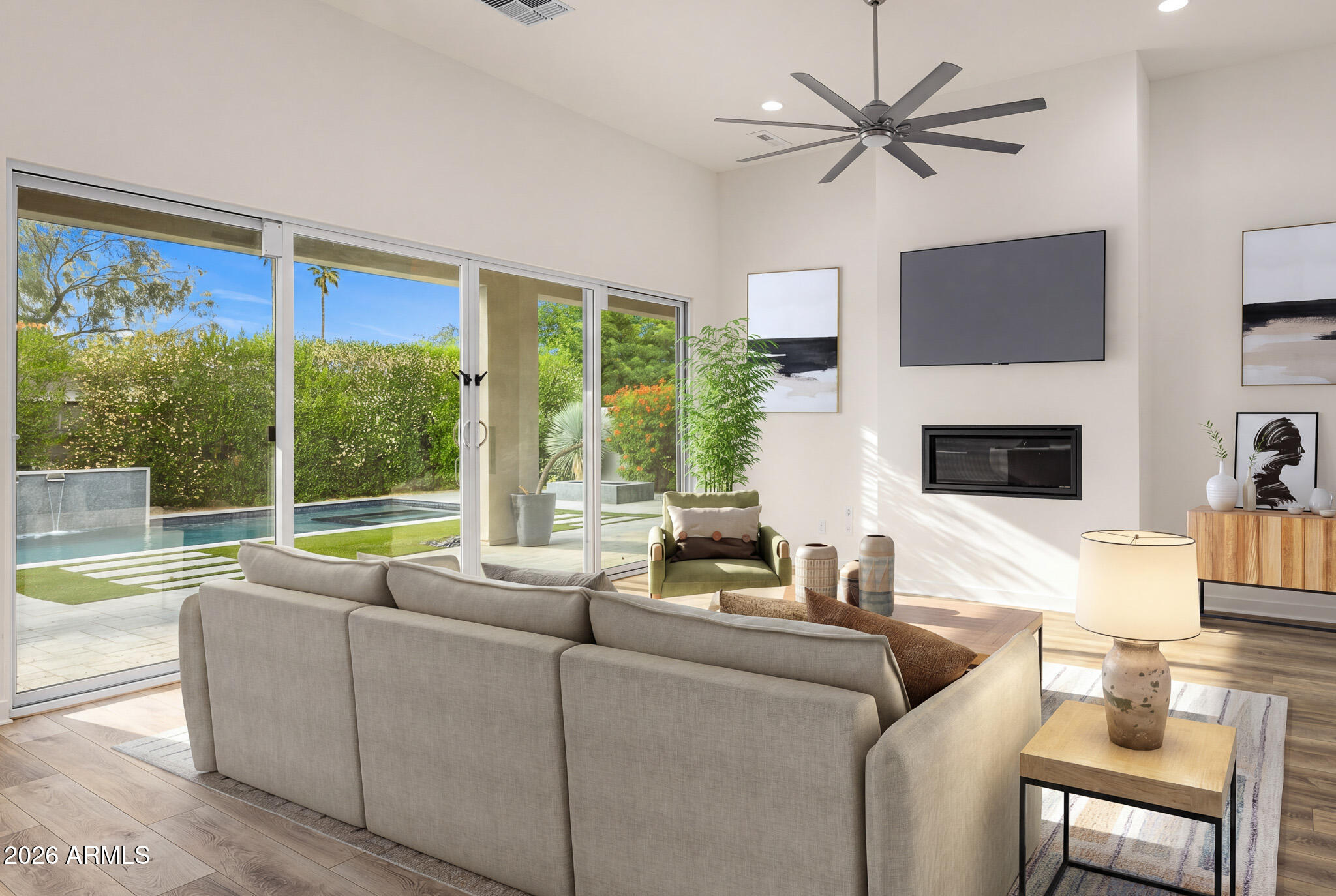 The ultimate lock-and-leave retreat in Paradise Valley, this beautifully designed residence is tucked within a quiet, private community and framed by mature ficus trees that create a serene, resort-like backdrop. Thoughtfully designed for effortless living, the home offers complete privacy, refined modern finishes, and an abundance of natural light throughout. Soaring ceilings and expansive windows elevate the interiors, while the elegant dining room flows seamlessly into a spacious open-concept family room that connects to the kitchen and sunny breakfast nook—ideal for both everyday living and entertaining. The chef's kitchen features high-end appliances, custom cabinetry, and a generous eat-in island designed for gathering. The primary suite is a true sanctuary, overlooking the pool and offering a stunning designer bathroom along with an exceptionally large walk-in closet with custom built-ins. The two additional bedrooms, bonus space, and 3.5 bathrooms provide flexibility for guests, family, or a home office. Outside, the private backyard is an entertainer's dream, complete with a sparkling pool accented by cascading water features, a large covered patio, fire pit, and ample space for outdoor dining and relaxation. Effortless, elegant, and impeccably locatedthis Paradise Valley home delivers luxury living with lock-and-leave ease.