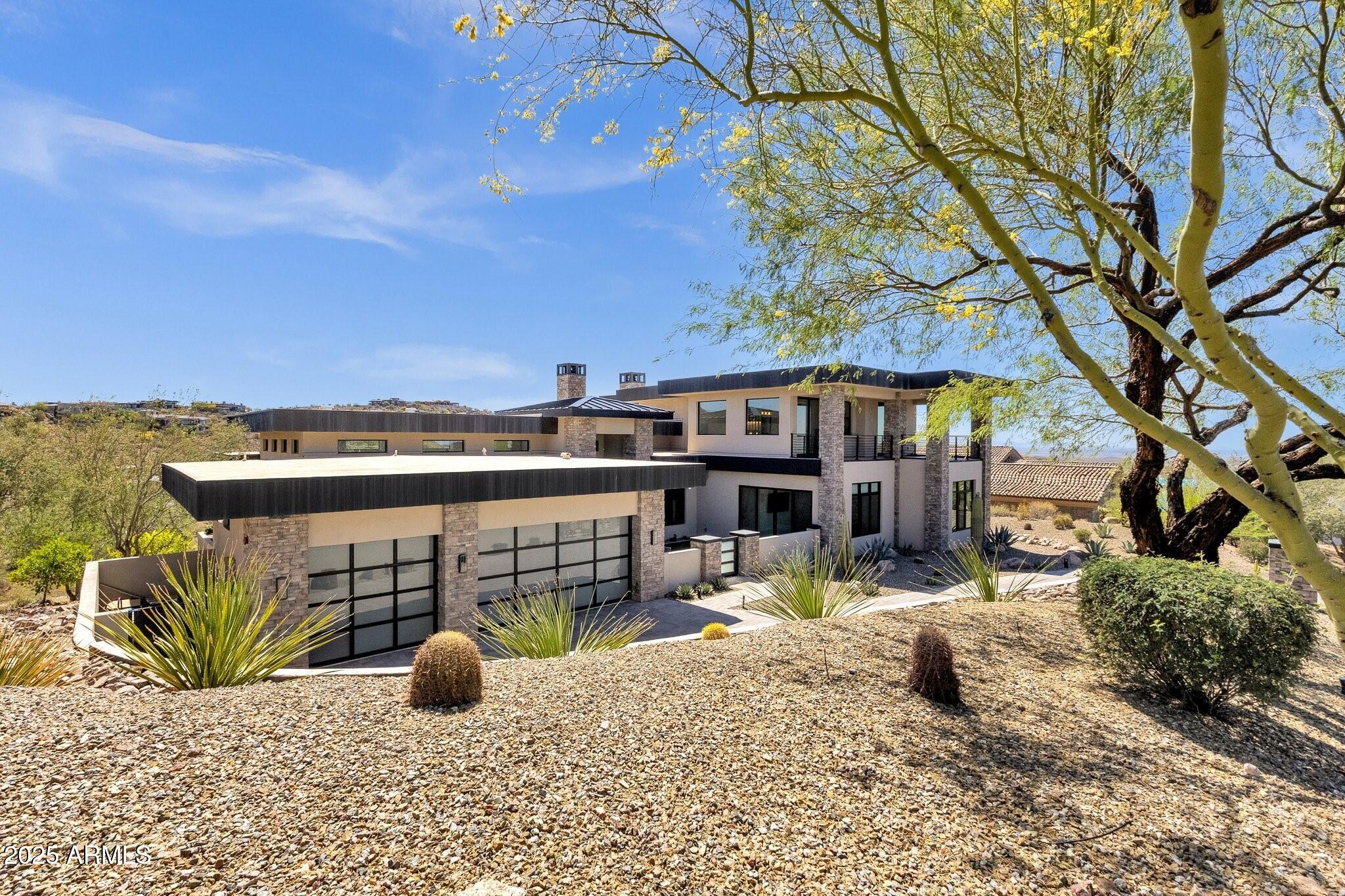 Sweeping views perched high above the 5th fairway! This striking contemporary residence is nestled within the prestigious guard-gated community of Firerock Country Club. This home blends architectural sophistication with state-of-the-art technology, including Savant home automation, including automated window shades, complete stereo audio and television control including Apple TV, full security automation, independent lighting control, remote garage door opening/closing, and even 9-ft sliding glass doors that open effortlessly at the touch of a button. Designed to live step free this home feels like a single-level home. All major rooms are on one level with 2 of the 3 ensuite guest rooms on the second floor. and accessed by elevator or stairs. The primary suite is a retreat offering a double-sided fireplace, and dual oversized walk-in closets. An additional den/office and flex bonus room on the main floor. Resort living with pool, spa, outdoor dining and firepit. patio heaters, and a full outdoor kitchenall framing breathtaking views. This is a rare opportunity to enjoy refined desert living with every luxury detail in place.