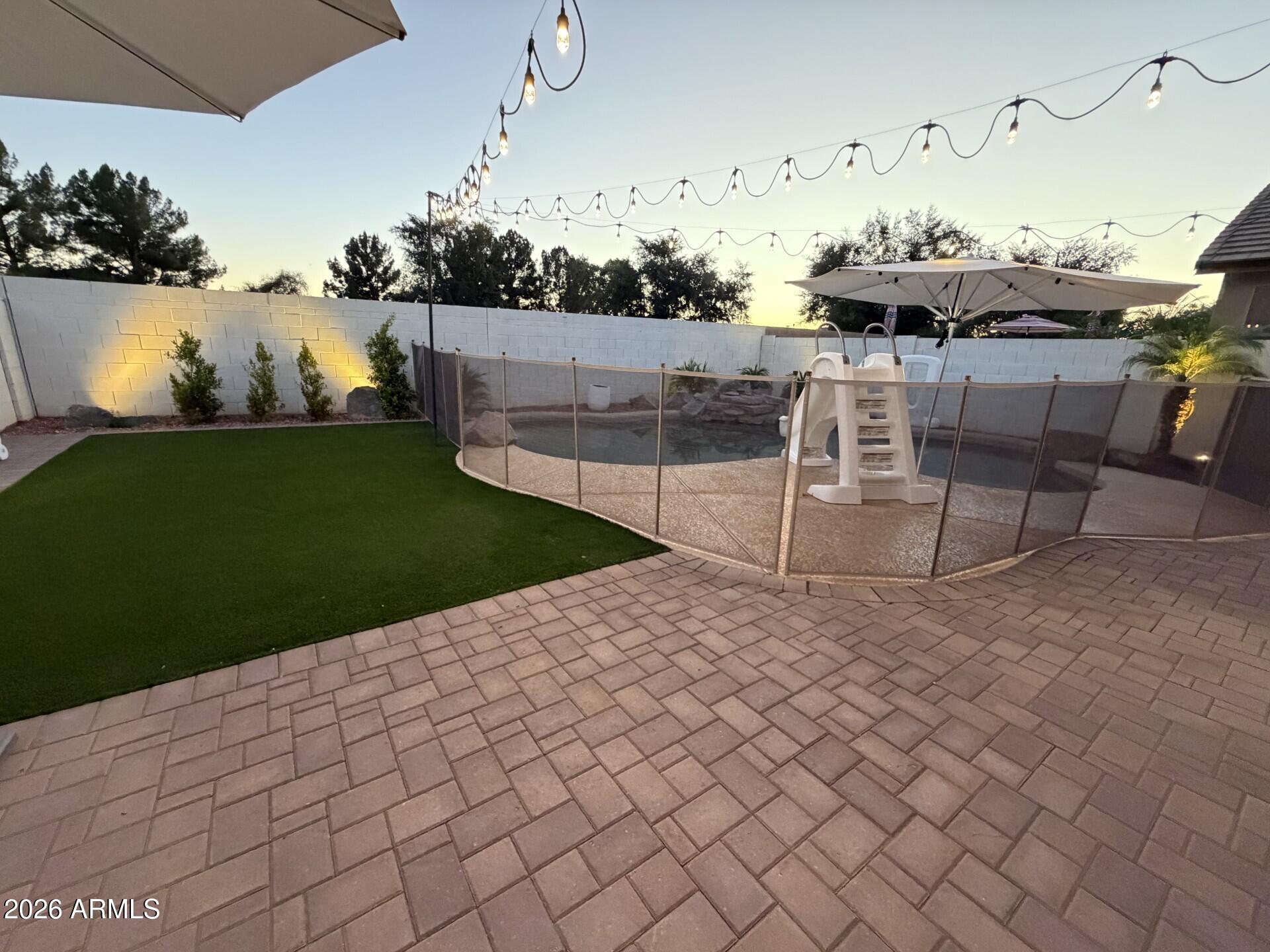 Pride of ownership shines brightly throughout this beautifully updated Litchfield Park home, which has been meticulously transformed to offer the ultimate blend of modern luxury and everyday comfort. Extensive renovations completed in 2022 immediately catch your eye with stunning high-end luxury vinyl plank flooring running seamlessly throughout the entire layout, perfectly complemented by bright recessed lighting, contemporary fixtures, and stylish ceiling fans. The heart of the home is a chef's delight, boasting refreshed cabinetry, gleaming quartz countertops, and a brand-new microwave and dishwasher that add exceptional value and convenience to your daily routine. Both bathrooms have been beautifully remodeled to feel like a private spa, highlighted by a gorgeous custom walk-in shower. The luxury extends outdoors to a backyard paradise that was fully transformed in late 2025 into an entertainer's dream, featuring expansive custom pavers, pristine artificial turf, and a dedicated dog run for your furry family members. When the sun sets, professional landscape lighting and cozy café-style string lights illuminate the space to create a magical ambiance for relaxing evenings under the Arizona stars. This private oasis is fully equipped for endless fun and memories, as both the thrilling pool slide and the basketball hoop convey with the property. Perfectly situated in a highly desirable neighborhood, this turnkey property offers an unbeatable location near Luke Air Force Base, top-rated schools, championship golf courses, pristine parks, premier shopping, fine dining, and the exciting new Litchfield development.
