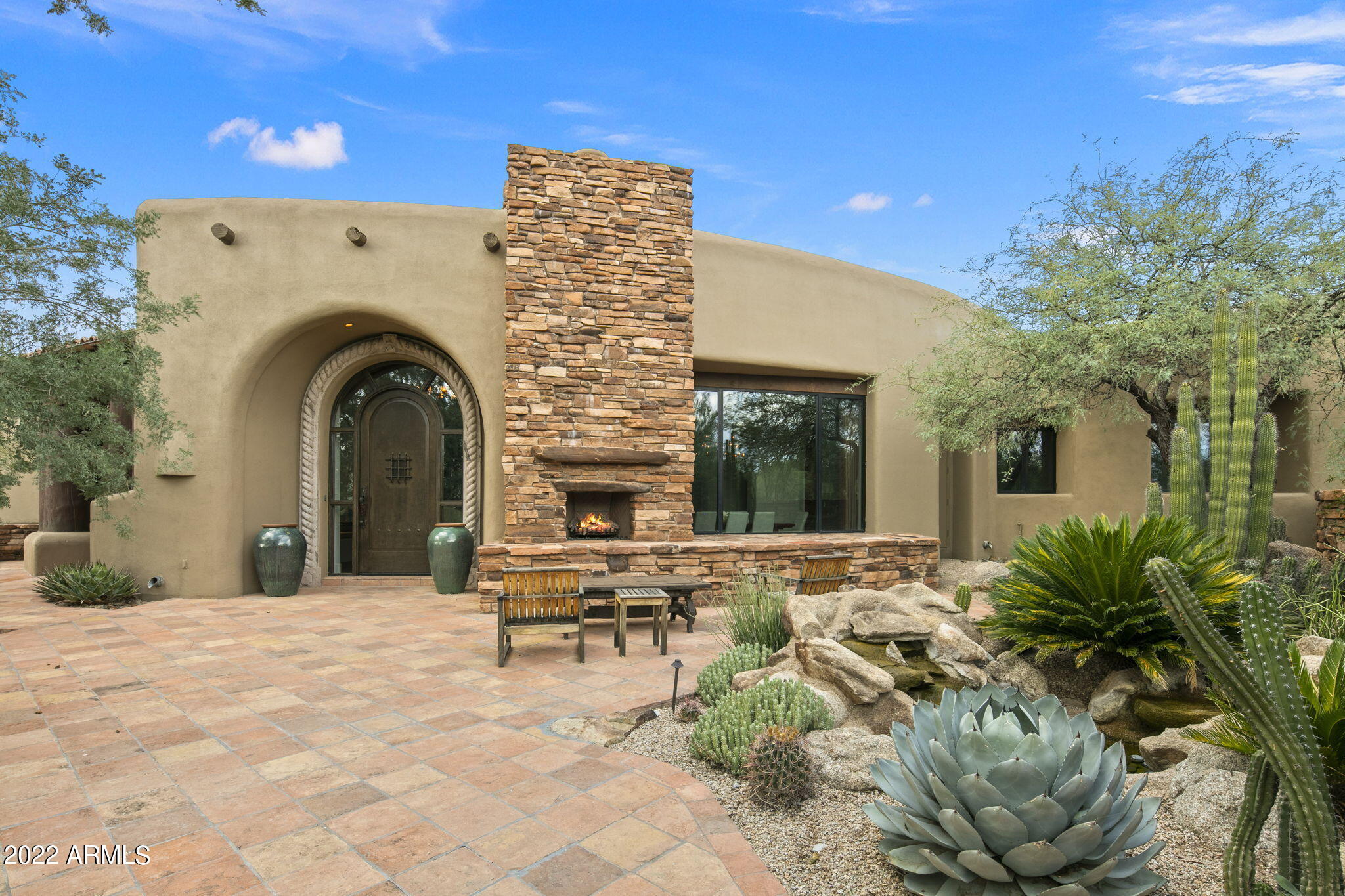 Full Golf Membership Available!* Exciting opportunity to own a quintessential Southwest Home designed by Lee Hutchinson, master of the southwest design. The home is sited on two lots and the Architectural Features are on display as you approach the home via the circular driveway. You are welcomed to the entry courtyard with an outdoor fireplace and serene water feature. The moment you step inside you are greeted with a vast view of the mountains looking past the living room. Five fireplaces throughout the home provide an ambiance of warmth and welcoming. Enjoy culinary experiences in the chef's kitchen that is spacious enough for guests to participate. All bedrooms are ensuite and have access to the sprawling outside living area which features a gigantic fireplace, sitting areas