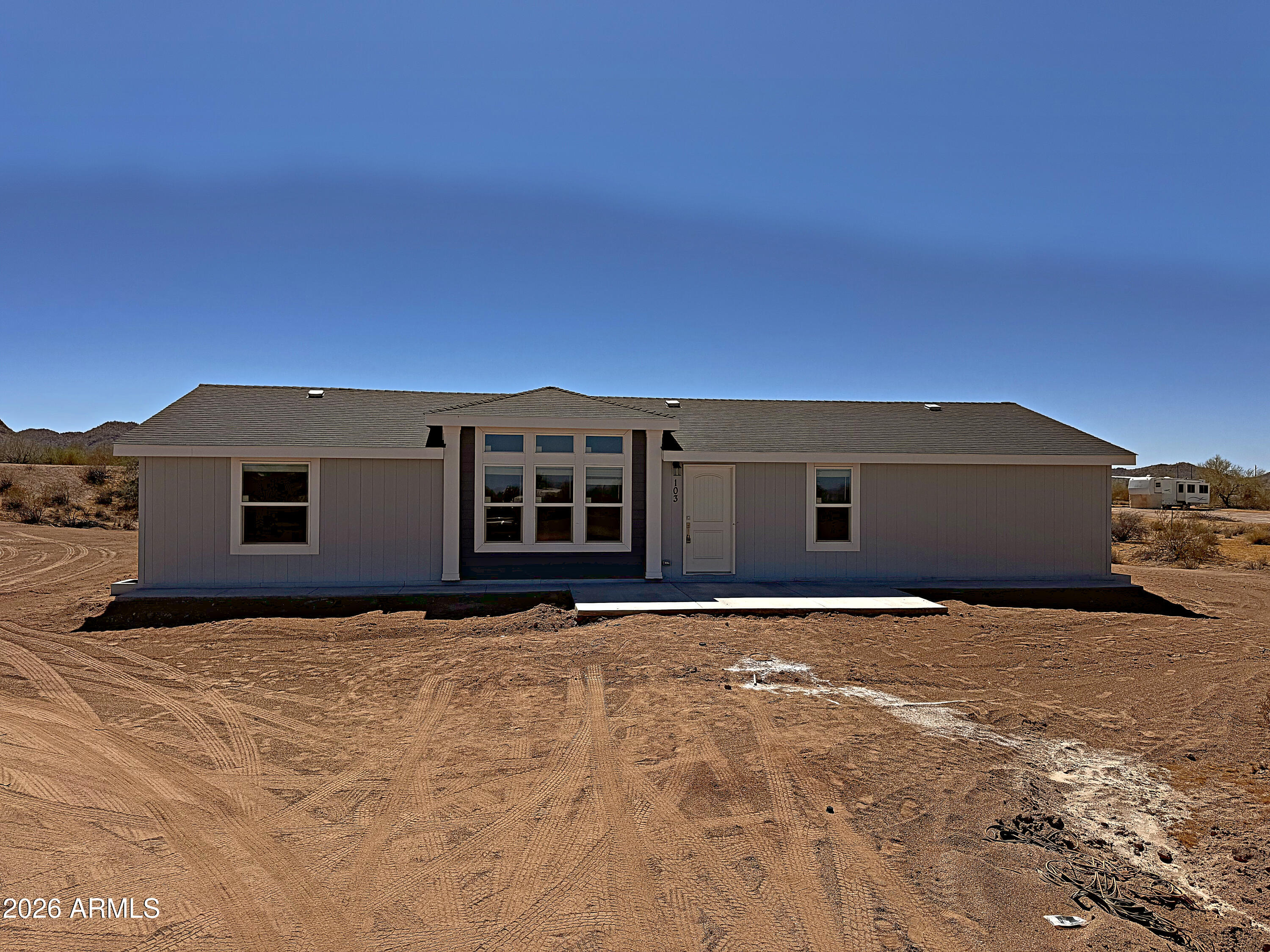 BRAND NEW in 2026, wide open, and ready for you. This ENERGY-EFFICIENT 4-bed, 2-bath home sits on over 2 ACRES with INCREDIBLE MOUNTAIN VIEWS, on a PAVED ROAD with NO HOA. Inside: 1,600 SQ FT of OPEN living under VAULTED CEILINGS, with a TOWER DORMER and COFFERED CEILING and LED lights. The gourmet kitchen features a large island, STAINLESS STEEL APPLIANCES, cimarron hardwood cabinets, off-white laminate counters and nickel hardware. A separate dining room opens to a rear patio. The LARGE MASTER SUITE has double sinks and a walk-in closet; the fourth bedroom opens to the living room through double doors, making it an easy DEN OR OFFICE. Smart thermostat, faux wood blinds and WASHER/DRYER INCLUDED. Concrete patios front and back, plus a NEW SHARED WELL and septic. ADDITIONAL HOMES AVAILABLE