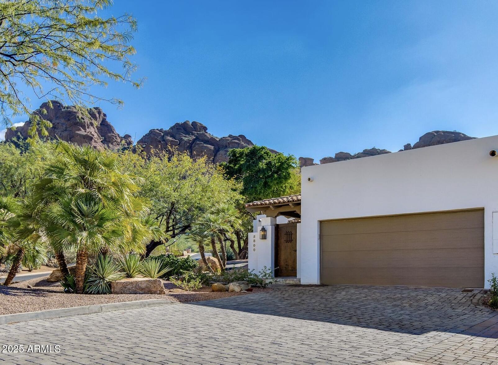 Nestled at the base of Camelback Mountain in the 24-Hour Guard-Gated Echo Canyon community, this fully remodeled luxury home on a corner lot is a blend of modern sophistication and timeless design. Every detail of this home has been meticulously crafted. The 3-bedroom, 3.5-bathroom retreat includes en-suite bedrooms, over $100,000 worth in custom millwork, an interior courtyard with a custom wall fountain, backyard with patio, fireplace, and heated spa, 2-car garage with charging station, three brand new AC units, a transferable roof warranty, and new electrical panel.