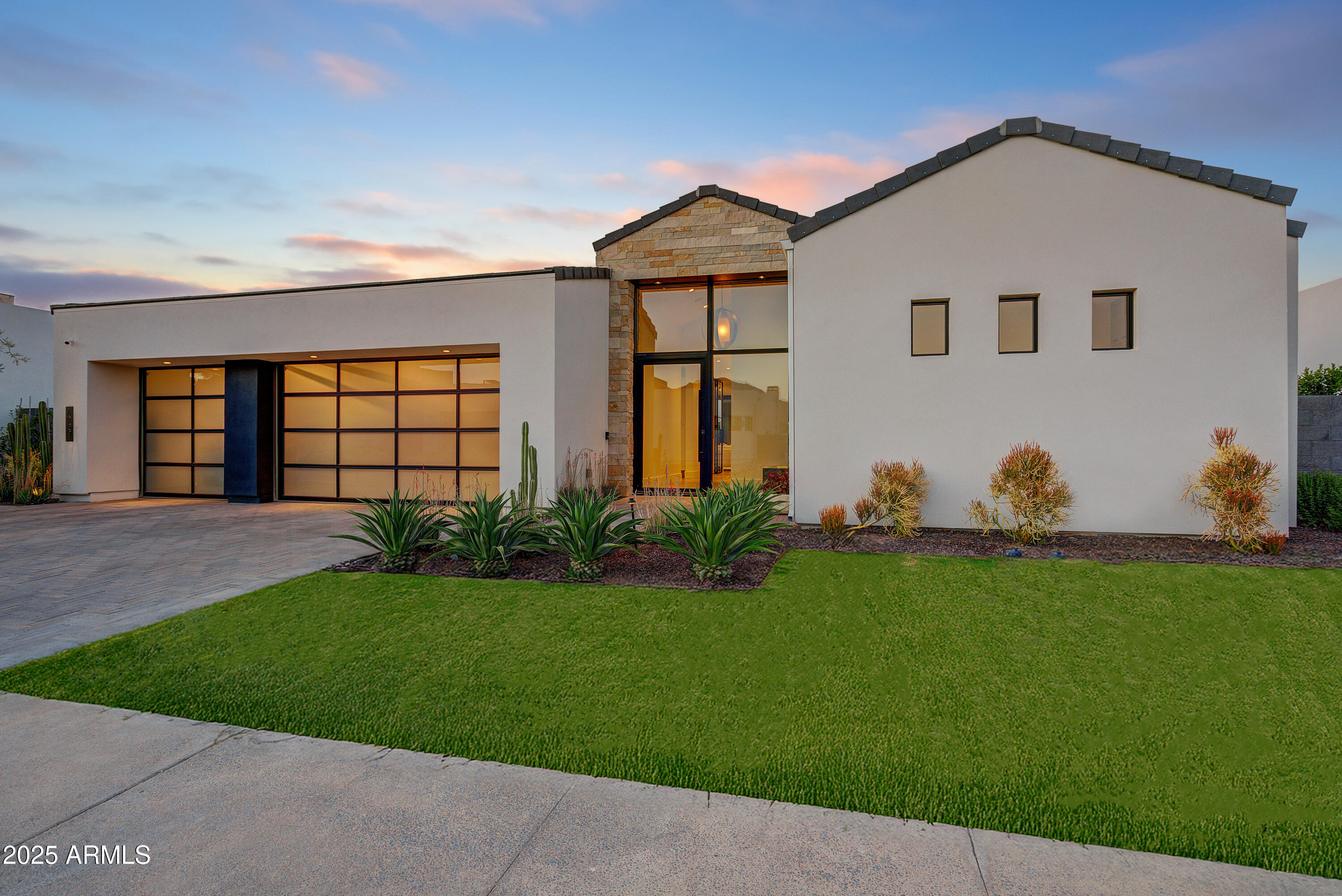 Contemporary jewel box in the guard-gated community of Azure adjacent to the Ritz Carlton in Paradise Valley. Dream team design group of PHX Architecture with finish selections by Ownby Design. Single-level home with a light and bright Great Room floor plan and zero interior steps. The open kitchen and Great Room flow seamlessly through a wall of glass to the outdoor living area and pool. Split floor plan with 3 bedrooms, 3.5 bathrooms and a dedicated office. The Chef's kitchen features Gaggenau appliances and a hidden butlers pantry with a separate walk-in pantry. The outdoor space includes a covered dining area with built-in heaters, large pool with waterfall wall, grassed dog play area and dog run and a gas fire pit seating area. An oversized 3-car garage completes the residence.