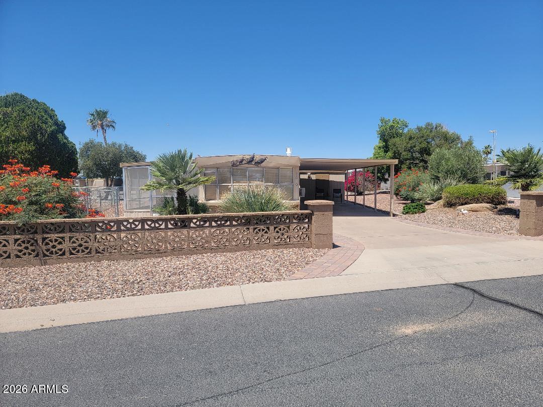 This is a lovely 2 bedroom 2 bath home. Partially furnished clean home  with all appliances that convey. The home has  updated features done with both bathroom fixtures, an flooring throughout.  The Ac wall unit in the family room is 3-4 years old. The roof was recoated in 2026. A full landscaped watering system was added, and water heater was replaced 2 years ago. The open floorplan is spacious and inviting! There is a 265 sq ft screened in Az room, and a fenced yard for your pet. A shed offers storage and the washer and dryer laundry area. This home is a wonderful, well taken care of Oasis and a great place to enjoy the lifestyle of Florence Gardens. Heated pools and spas, pickle ball courts, golf course, craft rooms, billiards hall, work out room, and library and more! You OWN THE LAND!