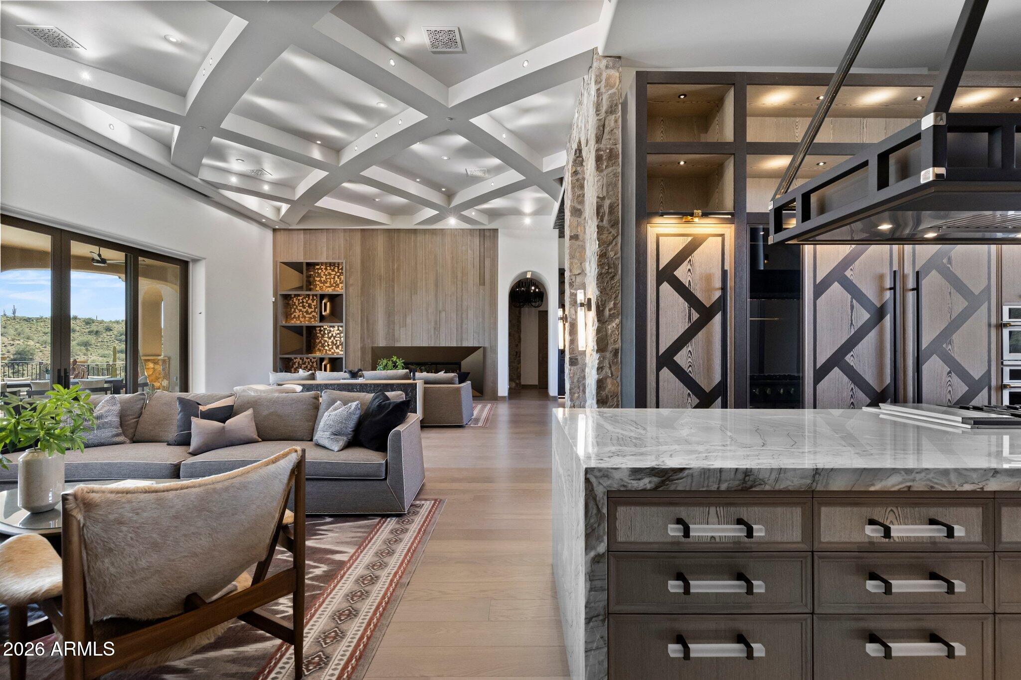 As featured in the June issue of So Scottsdale magazine, an architectural achievement reimagined by Jaque Bethke on an elevated 1+ acre lot in FireRock Country Club. This 6,007 SF, 5 Bed, 4.5 Ba, museum-quality residence blends raw elemental beauty with world-class technology. Anchored by three 3,000lb motorized amethyst/pink geodes, the home offers seamless single-level living via private elevator. Chef's kitchen features a 12' waterfall island & AI-powered hood. Wellness primary suite boasts Red Mountain views, 4-zone heated floors & steam closet. Fully automated via Josh AI, Control4 & Lutron. The ''Collector's Dream'' garage features 4 over-height, extended-length bays prepped for lifts to accommodate up to 8 cars. Entertainer's backyard with negative-edge pool & spa overlooking Four Peaks and City lights.  This is a curated journey in the Sonoran Desert, designed for effortless living and sophisticated entertaining.  The entire living experience is contained on a single main level. The culinary hub is a masterpiece of form and function, a 48" gas range, custom steel and light AI powered hood, and a high-utility butler's pantry. Adjacent to the casual living areas, the home offers a state-of-the-art home theater with a 10-foot screen, an executive home office, and guest suites featuring private balconies. Residents can enjoy the warmth of a sleek fireplace while taking in unobstructed, sweeping views of Red Mountain, creating a resort-level atmosphere within the home. With Smart Home technology, every element of the home's environment, from lighting and climate to security and media, is integrated for intuitive use.  The "Entertainer's Dream" backyard is designed to showcase Arizona's natural beauty. Expansive travertine patios offer a front-row seat to spectacular sunsets, shimmering city lights, and iconic views of Four Peaks and Red Mountain. With a built-in BBQ and multiple lounging zones, the outdoor space is an extension of the home's elemental luxury, completing this architectural masterpiece.