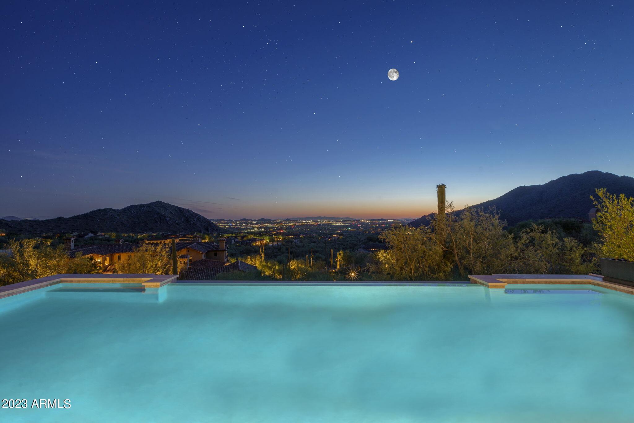 Absolutely Gorgeous Modern Luxury Estate in Silverleaf Upper Canyon!! This Rare Jewel purchased new Aug of 2020 was barely lived in as a part time residence and is being offered as a Turnkey Home that includes $1.1 Million of professionally designed furnishings, artwork, rugs, accessories, technology, & housewares making it easy to move right in. Breathtaking panoramic city light & mountain views are unobstructed from this elevated homesite and offer both privacy and views. This well designed functional open floorplan was created by renowned architect CP Drewett and is sure to impress with exquisite finishes and furnishings only surpassed in grandeur by the incredible infinitely impressive views. The Main level includes Primary bedroom & two other full bedroom suites, Great Room, Dining, Kitchen, Walk-in Pantry, Lounge/Bar Room, Pool Table Room (could be an office), Laundry/Mud Room, Powder Bath, AV Room, Elevator, and Garage. The Lower Level includes a Media Room, three Bedroom Suites, Storage Room, and Elevator.
There is a beautiful light filled wood & iron staircase or choose the Elevator to take you effortlessly between the Main & Lower levels. 
Some of the amazing features of this home are: wood flooring throughout except baths & laundry, designer rugs in most rooms, built in automated shades or draperies, designer touches at tile in bathrooms & other tile areas, impressive light fixtures, wallpaper in several rooms, Control 4 Home Automation system plus Lutron Lighting & Shade Control systems, outdoor security cameras as well as inside the garage, music throughout all main interior & exterior areas, limestone trim at exterior elevation & patio floors, wood plank patio ceilings, 3 laundry rooms, and stone clad fireplaces. 
The large Great Room has a floor to ceiling stone slab fireplace, Dining w/ a wine display wall with lockable glass doors.
Kitchen w/ 2 islands, 60" Wolf range, Subzero R&F, 2 dishwashers, veggie sink, & tons of storage, and a large walk-in Pantry with adjustable shelves including cabinets for storage & countertop space for staging.
Lounge/Bar Room w/ access to front courtyard seating area, floating display shelves, sink, refer & ice maker, and lots of storage.
Pool Table Room off of the Great Room area could be used as an office instead.
Spacious Primary bedroom w/ beautiful fireplace & tv above, bi-fold door system that opens onto a covered patio w/ a hanging couch, and floor to ceiling automated draperies.
Primary bath w/ lots of natural light, free standing tub next to doors that open out to a balcony w/ views to the city, large shower w/ floating bench, coffee bar w/ built in coffee maker & refer, spacious vanities w/ linen storage & plenty of drawers, and his & her toilets. 
Large Primary closet w/ natural light, built in dresser, adjustable shelving, and laundry room. 
Guest Suite w/ separate living room & coffee bar, two bathroom sinks, and direct exterior access to front courtyard areas.
Powder bath w/ textured stone wall, floating vanity and a window for natural light.
Spacious covered patio off Great Room w/ tv & limestone clad fireplace, other covered patios and decks for dining and lounging, built in Wolf barbecue, and a negative edge heated pool to soak up the amazing views. 
Large Media Room w/ candy bar, refer, and microwave downstairs to take in your favorite movie or show.
One of the lower level bedroom suite bathrooms doubles as a guest bath for the Media Room and Swimming Pool.
Lower level covered patios w/ outdoor Ping Pong table & multiple seating areas, adjacent turf area, & exterior stairs up to the pool level. 
8-car Garage features air-conditioning, security cameras, epoxy coated floors, wall mount door openers and two car lifts with a spacious garage courtyard turnaround area that feeds all 5 garage doors.

Silverleaf, located in North Scottsdale, Arizona, is a prestigious guard gated community known for its luxurious estates, exclusive golf courses, private Club and stunning desert landscapes. The Tom Weiskopf-designed Silverleaf Golf Course is a highlight for golf enthusiasts. With a blend of Spanish and Mediterranean-inspired architecture, the community offers a high standard of living, including upscale amenities like spas, fine dining, and exclusive shopping. Residents enjoy a harmonious balance between modern luxury and the natural beauty of the desert environment, making Silverleaf a sought-after destination for those seeking an exceptional lifestyle in North Scottsdale.