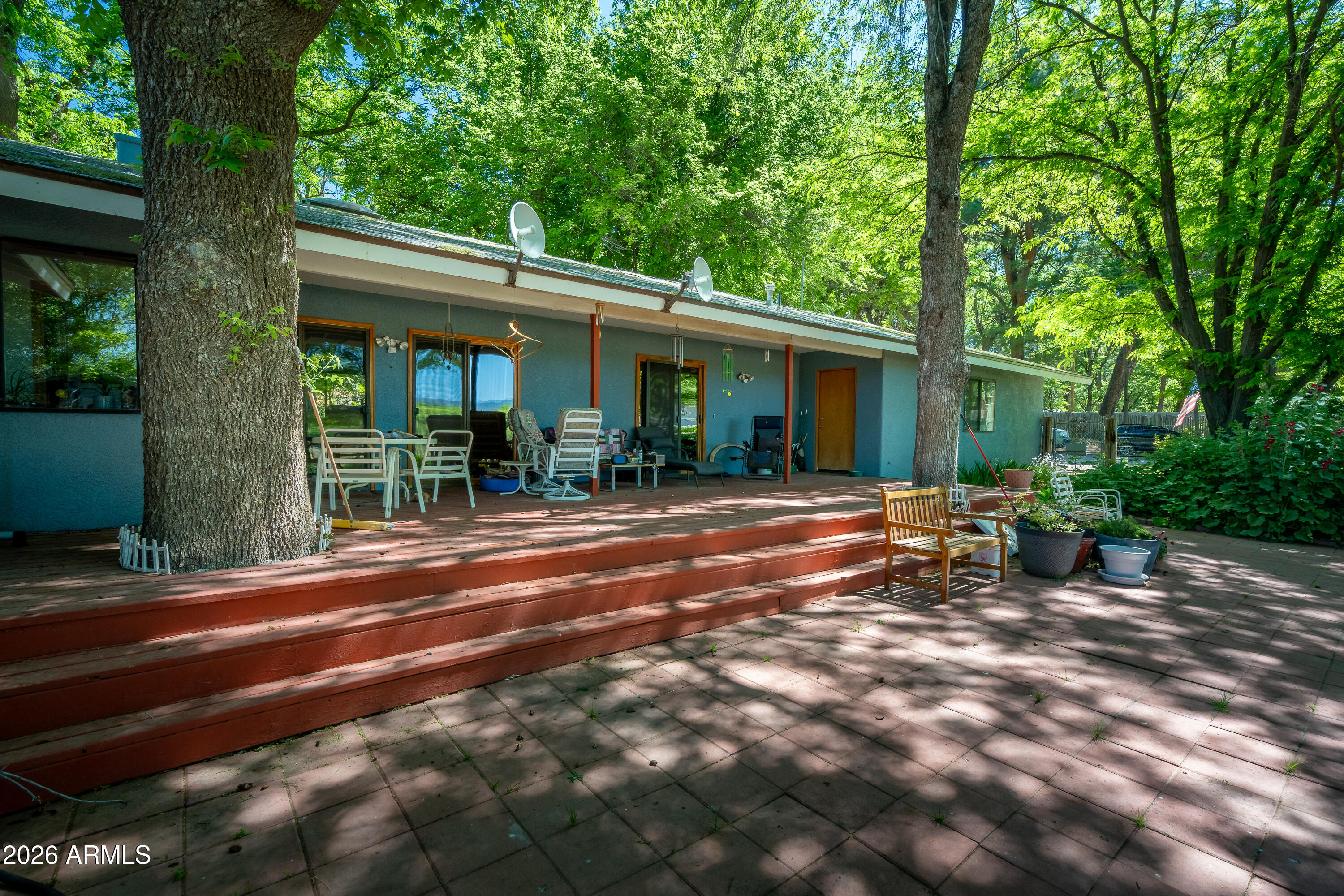 This truly marvelous property captures your attention the moment you turn down the lane ending as the property opens upon an expanse of shaded greenery and gardens, with 10 acres (approximately 5 irrigated ) of pasture that goes all the way to the Verde River. Inside this custom built 3000 sq. ft. 3Bed/3Bath, 3 car garage Marin County ranch style home has exemptional attention to detail including, River Birch trim and doors, Saltillo tile hand picked Talavera inlay, an expansive Primary Suite, and solarium which is currently used as a home gym. Plus floor to ceiling built-ins in the secondary bedrooms, surround sound in the Great Room, new pellet stove, and approximately thirty owned solar panels for maximum energy efficiency. ..,with formal yard and gardens, barn, and pasture beyond. This is a spot that is perfect for entertaining and keeping an eye on your four legged friends....The nice sized barn has three stalls with runs, turn-out area, hay barn, round pen and a gorgeous grove of fruit trees.