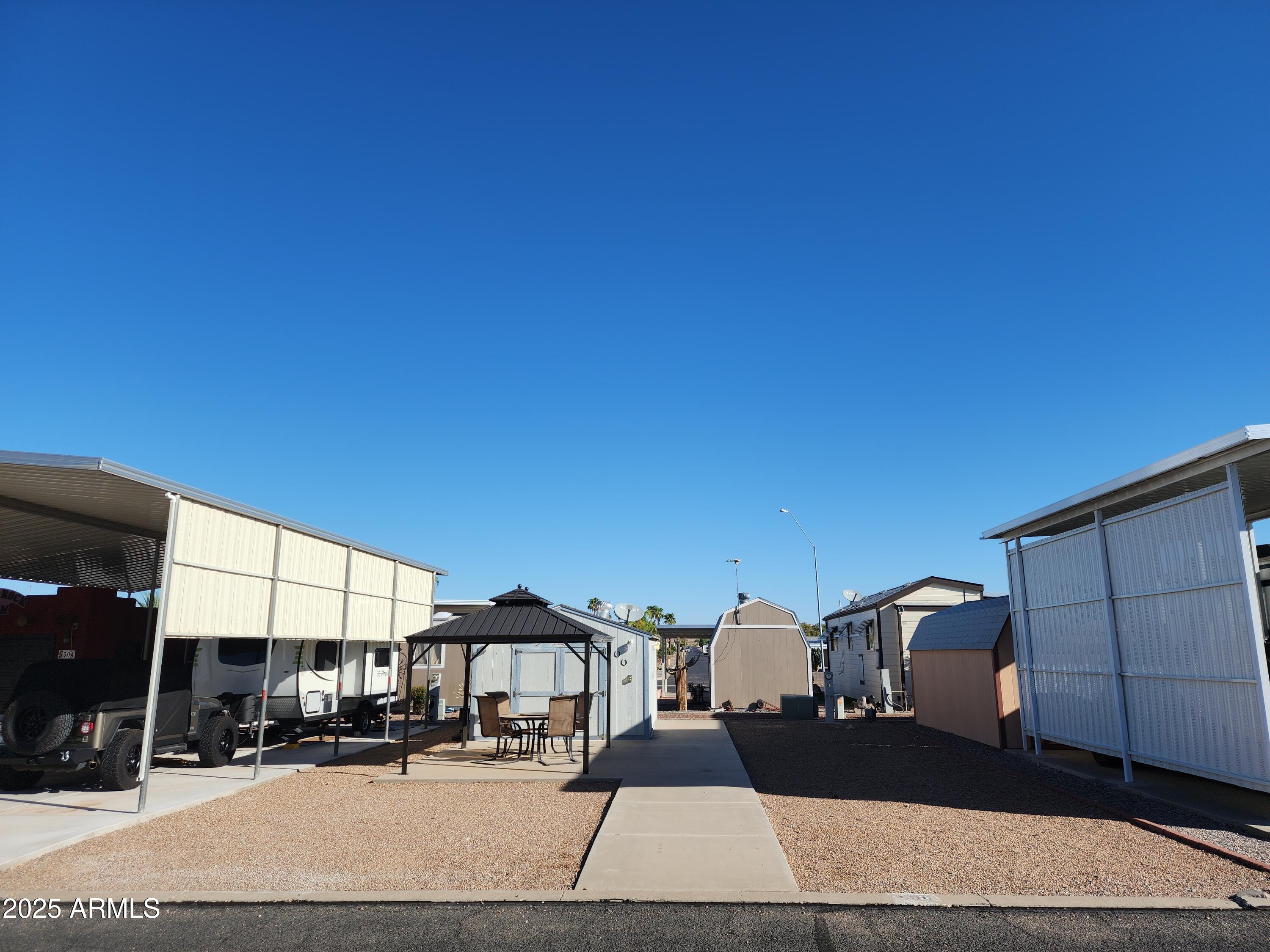 A wonderful lot currently set up for a motor home or a Park Model Home could be installed. Water and power are on the property already. The property has a large concrete pad with a large shop with plenty of space and a work bench and good lighting inside. Also, a new covered Cabana has been installed and anchored to the concrete with 4 nice chairs and swivel top serving tray. The concrete pathway extends from the patio to the street so you can step out of your motorhome or Park Model onto the side walk instead of the decorative rock. Tierra del Sol is a 55 Plus community where you own your land so no lot rent fees. There is a nice club house with gated pool area attached and an executive gold course just 3 blocks up the road. Enjoy the southern exposure with your coffee each morning.