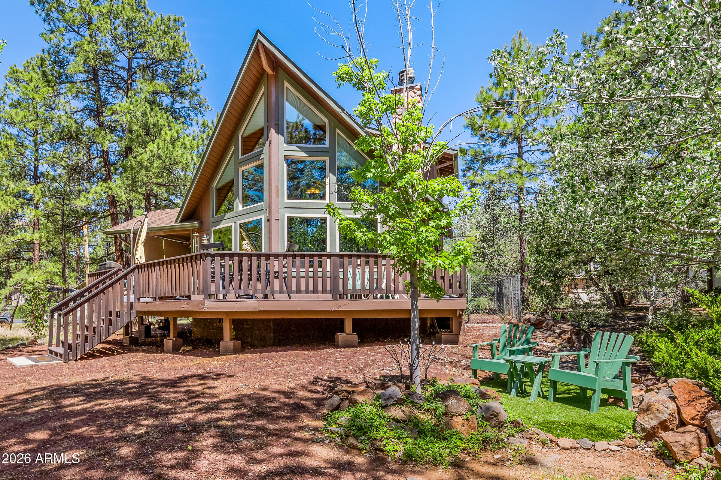 This mountain chalet is the cabin you've been dreaming of. With great curb appeal and meticulous care, it shows like new. The striking prow-front design features new Milgard UV-protective windows (throughout the house) that fill the home with natural light and bring the outdoors in. The wraparound Trex deck offers both covered and open-air spaces, while privacy shade screens create a comfortable outdoor living area. Inside, vaulted T&G ceilings and a stone-faced wood-burning fireplace highlight the great room, which flows seamlessly into the dining area and inviting kitchen featuring hickory cabinets and a breakfast bar. The primary suite is conveniently located on the main level with a private bath. Upstairs, you'll find two additional bedrooms, a full bath, and a versatile loft that can serve as an office, family room, or extra sleeping space. Additional features include central air conditioning, a fenced backyard, an oversized storage shed with a ramp that can house your razor or side by side, AND plenty of parking too. This move-in-ready mountain retreat is one you won't want to miss. Offered mostly furnished too!