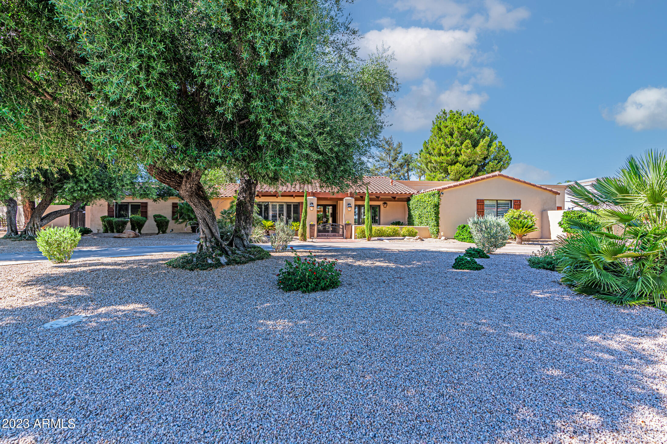 A magnificent home located on one of the most desirable cul-de-sacs in Equestrian Manor—a highly sought after guard gated community. This home is a true find because houses in this neighborhood rarely go up for sale and this particular lot is extremely quiet with no traffic noise. The open floor plan features warm hardwood floors, elegant cabinetry, crown molding, charming fireplaces and wood-beamed and vaulted ceilings. The large gourmet kitchen is a chef's dream that flows into a delightful breakfast area and large family room perfect for gatherings. This spacious home also has 6 bedrooms with one set up as a bonus room. The primary suite includes a cozy sitting room, walk-in closet and lovely bath. Situated on close to an acre of land, this lush, resort-like backyard boasts mature landscaping, a field of grass, beautiful pool, gazebo, roomy covered patio and lots of outdoor living and entertainment space. What's more, this amazing community is centrally located in Scottsdale near the best schools and close to great restaurants and shopping.