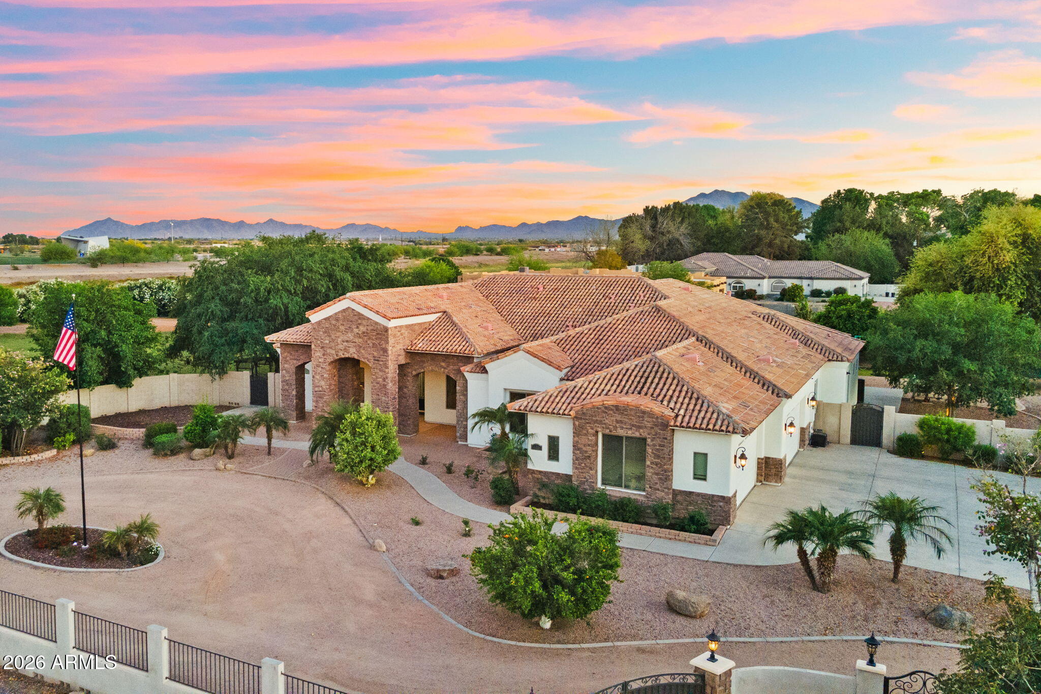 Rare opportunity to own a private gated estate on nearly 2 irrigated acres in a desirable R-43 County Island setting just minutes from Downtown Gilbert. This single-level residence features 5 ensuite bedrooms, each with its own private bathroom, plus a pool bath and dedicated office with private exterior entrance. Resort-style outdoor living includes a pool, spa, swim-up bar with built-in seating, shaded gazebos, and expansive covered patios. The irrigated grounds showcase raised garden beds, vineyard-quality grapevines, mature citrus, peach, apricot, fig, pear, and plum trees. Additional highlights include canal and trail access, observation deck views, four-car garage, extensive parking, and a high-efficiency variable-speed HVAC system installed in 2025. One of the property's most compelling features is the nearly 2 acres of irrigated land surrounding the residence. Positioned near the center of the parcel, the home leaves substantial usable acreage available for future expansion and customization. The combination of R-43 zoning and the County Island location creates opportunities rarely found this close to Downtown Gilbert. Whether your vision includes detached garages, workshops, guest casitas, multi-generational living, sport courts, additional gardens, or expanded outdoor amenities, the property offers exceptional flexibility. The mature orchard, vineyard-quality grapevines, raised garden beds, flood irrigation, and established shade trees create a setting that would take years to replicate, providing both immediate enjoyment and long-term value.
Arrival & Grounds: Entry begins through a secure gated compound featuring three vehicle gates, including a primary automated entrance that opens to a sweeping circular driveway and expansive motor court designed for ease of access and impressive arrival. Mature landscaping and shade trees frame the approach while the surrounding acreage provides separation from neighboring properties. Private road access enhances privacy and convenience. A private gate leads directly to the adjacent canal and trail system, offering opportunities for walking, cycling, and outdoor recreation. An elevated observation deck provides views of the surrounding landscape and nearby regional park lake while capturing sunsets and community events in the distance.

The expansive irrigated acreage offers exceptional flexibility for outdoor living and land use. Livestock and horses are permitted on the property, creating opportunities for equestrian use or hobby farming. The grounds provide ample space for horse stalls, barn structures, or animal enclosures, while still maintaining generous room for gardens, orchard areas, and outdoor entertaining spaces.

Residence: The estate features a spacious single-level custom residence with over 4,100 square feet designed for comfortable living and entertaining. The floor plan includes five bedrooms plus a dedicated office with private exterior entrance, ideal for a home office, studio, or meeting space. The home offers six bathrooms, including a convenient exterior-access pool bath designed for guests enjoying the outdoor amenities. Architectural details throughout include three fireplaces, real wood flooring, crown molding, oversized baseboards, and extensive custom cabinetry and built-in storage. The split floor plan allows the primary suite to remain private while secondary bedrooms provide comfortable accommodations for family and guests.

Primary Suite: The primary retreat offers generous space and a spa-inspired bathroom highlighted by an extraordinary walk-in shower and large Jacuzzi soaking tub, creating a relaxing environment designed for comfort and rejuvenation.

Secondary Bedrooms: Each additional bedroom features its own private bathroom and walk-in closet, creating privacy and flexibility for family members, guests, or extended household living.

Kitchen & Gathering Areas: The kitchen and gathering spaces are designed for connection and entertaining, featuring granite countertops, generous preparation areas, and open living spaces that flow naturally into the surrounding entertaining areas.