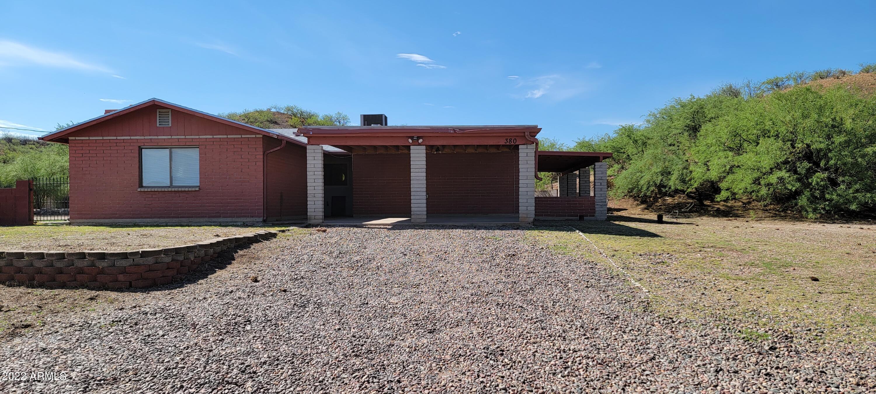 This is a great price on this large home with a HUGE finish outbuilding and animal pens. The home features a large living room and a separate family room, both with wood burning fireplaces. The kitchen has ample cabinetry and counter space with a view to the north from the the kitchen window. The dining room has french doors that lead out to the covered patio on the east. The master suite is lovely with a lighted headboard area, very large closet plus a large storage area that could be an additional closet, safe area ?? The secondary bedrooms are all good sized. Tere is room to park at least 2 cars under the carport in front. This must be an AS IS sale. The seller is unable to make any further repairs to the property.