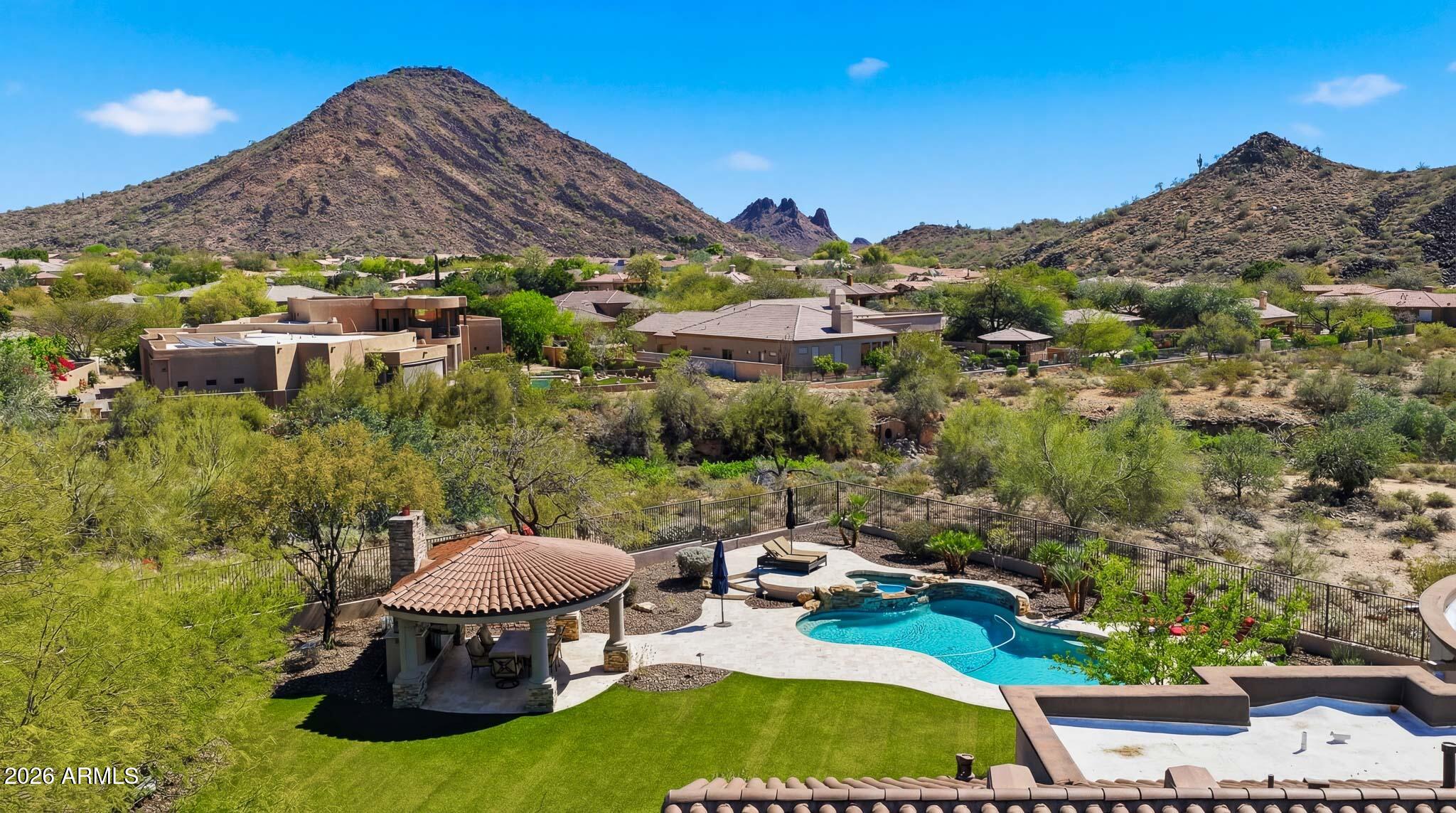 Set against sweeping mountain views, on over 1.5 acres, this beautifully updated custom residence blends timeless architecture with refined modern finishes. A private courtyard entry leads through an iron door into a grand interior with soaring ceilings and expansive windows. Expansive living spaces offer an effortless flow for both everyday living and entertaining. Each bedroom is ensuite, large enough for a king bed, and has an ensuite bathroom! At the heart of the home, the fully remodeled kitchen features custom cabinetry, Thermador appliances, and quartzite countertops, opening seamlessly to the family room and bar area. Expansive outdoor living areas overlook the mountain views, creating a stunning backdrop for both entertaining and everyday desert living! This won't last, so hurry! This home has a long driveway for plenty of places to places to park your cars and RV gate for all your toys! Many costly updates including new underlayment and tile roof, fresh interior and exterior paint, new landscaping lighting, new custom light fixtures throughout and newly replaced ac units too! See documents tab for full list and come take a look at your new home today!