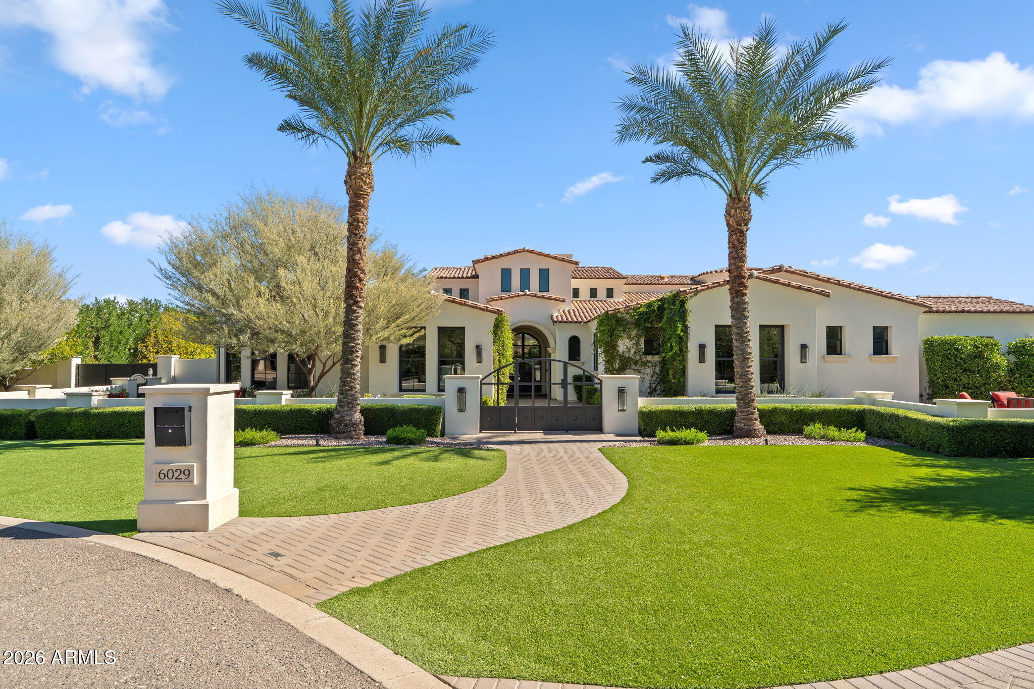 Perfection in PV! This exceptional 6-bedroom, 5.5-bath residence with a 5-car garage offers over 7,400 square feet of thoughtfully designed living space, nestled on a private cul-de-sac lot in the heart of Paradise Valley. A timeless Mediterranean exterior paired with a warm transitional interior creates the ideal Arizona retreat.
The home offers an attached guest casita, white oak flooring throughout, casement windows, powered window treatments, four masonry fireplaces, a dedicated theater room, a fully integrated Control4 smart home system, and custom designer finishes at every turn.
The expansive chef's kitchen is ideal for both everyday living and entertaining, showcasing dual oversized islands, Sub-Zero refrigeration, Cove dishwashers, a 48-inch Wolf range, ((Continued)) multiple ovens, custom painted cabinetry, and stunning marble countertops.
The primary suite serves as a private sanctuary, complete with its own fireplace, direct access to the backyard, and a spa-inspired marble bath with dual vanities, an oversized shower, a soaking tub, and separate his-and-hers walk-in closets.
Step outside to a true desert oasis featuring multiple covered patios, an outdoor kitchen, a cabana with fireplace, and a separate elongated fire pit. The resort-style pool includes a large Baja shelf, multiple water features, and a striking vanishing-edge spaperfect for relaxing or entertaining year-round.