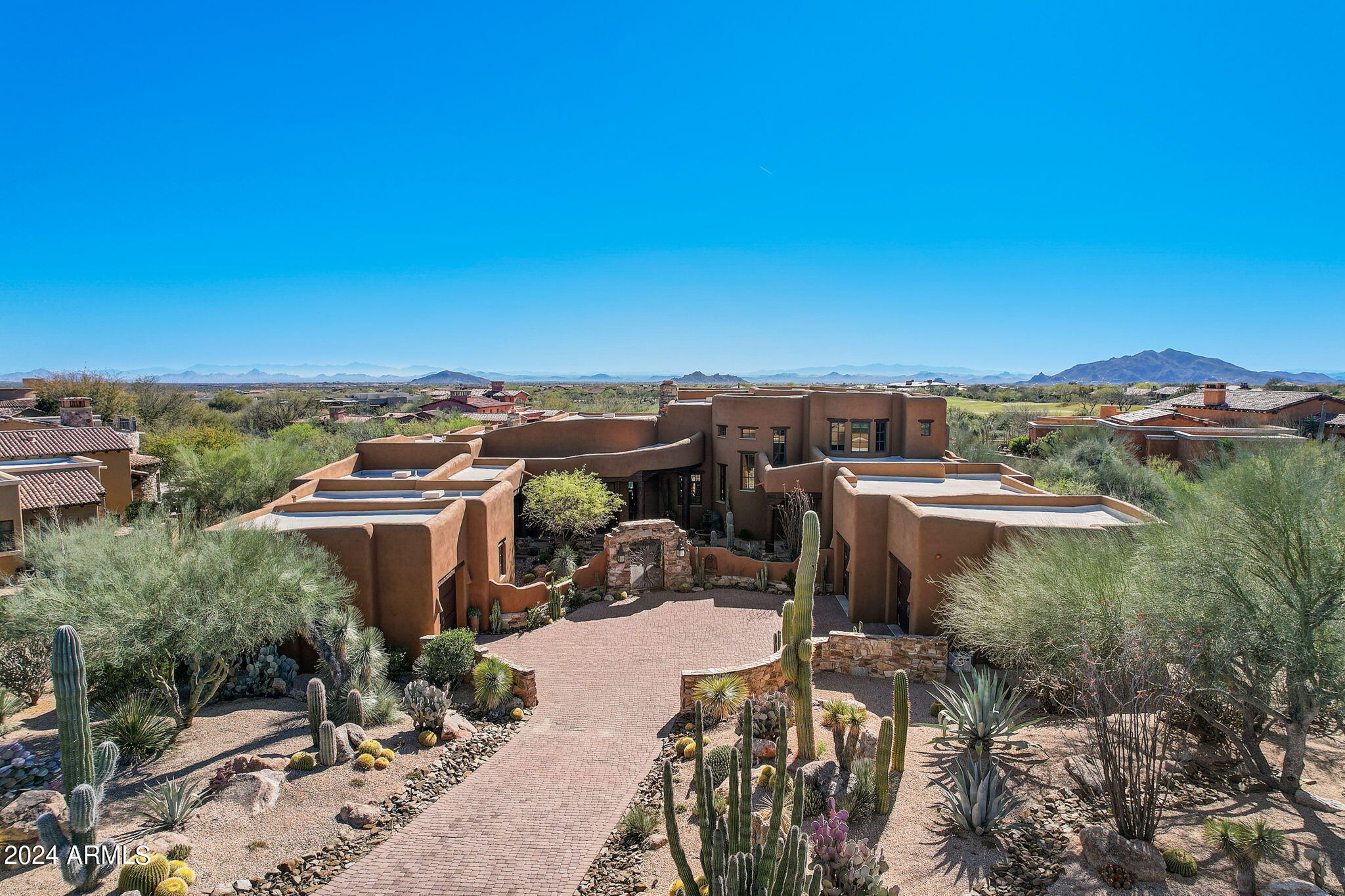 This high-quality custom home with sunset views in guard-gated Mirabel Club is being sold COMPLETELY TURNKEY and is truly ONE OF A KIND, with quality materials that cannot be built for even close to this price today. As you approach, you'll notice the pristine curb appeal, in low-maintenance desert landscaping. The courtyard with wrought iron gate and water feature sets the mood upon arrival, and provides a central meeting space for your guests, with covered patios for both the guest house and one of the guest suites. Before stepping inside, take a moment to appreciate the 9.5' custom alder door, an impressive piece on its own. Upon entry into the living room, you'll immediately notice the thoughtful design, quality finishes, breathtaking views, sunset bronze flagstone flooring, massive two-way stone fireplace, and beamed ceilings. The entertaining area includes a full wet bar with copper sink and under-counter drink fridge. Imagine hosting your friends in this dining room while enjoying sunset views out your window. The ironwork on the wine cellar is another nod to the thorough attention paid to every detail.

Continue toward the kitchen, first stopping at butler's pantry with ice maker and dual-drawer dishwasher. The kitchen is comfortable yet luxurious, from the hand-finished alder cabinets to the herringbone terra cotta backsplash. High end appliances include 48" Wolf gas cooktop, Wolf carbon finish dual-ovens, microwave, and warming drawer. There is abundant cool storage, with a full-size fridge plus two cooling drawers along with a full-size freezer plus two freezer drawers, all Subzero. Continuous hickory flooring connects the kitchen and family room, with vega beams radiating out over the curved room, seamlessly connecting them into a flowing great room.

Across the home you'll find the owner's wing. The office features square wood beamed ceilings, with that square pattern duplicated on the hickory flooring below. The ample primary suite is complemented by a sitting room with kiva fireplace, a perfect place to take in the stunning views. The primary bathroom includes the same quality finishes you've seen throughout, from the travertine slab countertops, alder doors, down to the rustic iron towel holders. Completing the primary suite is the oversized closet, with built-ins from wall to wall.

Multiple guest suites provide privacy for all of your family and friends. First, upstairs you'll find an ensuite bedroom with their own loft living room, and access to the rooftop deck with amazing views. Also within the main house is a second ensuite bedroom. For additional guests, through the front courtyard is a full guest house, with living room and half-kitchen, private patio, large ensuite bedroom, and direct access to the third garage bay.
Even the fundamentals have been recently updated. The entire roof was recoated (2021), and all four AC units and two furnaces replaced (2021), as well as two large water heaters with recirculating pumps replaced (2020). Outside, the landscaping was redone with the entire irrigation system replaced (2021). The pool was resurfaced with mini-pebble finish, tile edge, and travertine coping, along with a wi-fi Aqualink control system added (2021) and the pool heater replaced (2020).

Finishing off this home is precisely where you'll want to unwind every evening, in the spacious and gracious backyard. The covered patio extends the length of the home, and includes an outdoor fireplace for those cool nights. Two additional uncovered seating areas offer options for taking in the sun. Entertain at the built-in BBQ, and don't miss the outdoor half bathroom. The backyard is a serene high-desert landscape, strategically placed to take in the picturesque Arizona sunsets while overlooking the golf course. Located toward the end of a cul-de-sac, so extremely light traffic, and all adjacent homesites have already been built.
Mirabel's weather is famously dry and sunny. Our risk of natural disasters is extremely low. Being higher and somewhat removed from the city means the stars are bright at night, the air typically much cleaner, and the daytime high temperatures can be about eight to ten degrees cooler than the Valley floor, every day of the year. You would be amazed how comfortable 95 degrees is at night or in the shade. So, being in Mirabel on a year-round basis is an attractive proposition.

In addition to the endless shopping and fine dining options all just minutes away, the owner of this home will be close to major league and collegiate sports, fabulous medical care (including the Mayo Clinic and hospital), terrific air service, and a wide variety of cultural attractions. This home is truly one of a kind and I encourage you to come see it today, and you'll be glad you did.