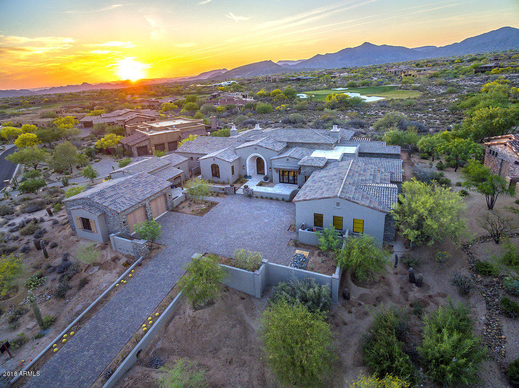 If you are looking for one of the finest custom built homes in North Scottsdale - look no further! This Poetzl Architecture designed & Lineage Homes built custom features an open & flowing floor plan & a stunning golf course, mountain view and sunset lot! The main home is 5571 sq ft & features a spacious great room w/fireplace & a wall of retractable doors open to the gourmet kitchen w/beautiful custom cabinets, high end counters materials &  high end appliances.There is a breakfast nook and a full wet bar w/windows that fully retract as well. There is a separate dining room with a walk in glass wine room. Master is large with a fireplace, luxurious bath and huge walk in closet. Two additional bedroom suites & powder bath. 2 room 703 sf guest house w/wet bar. Pool,spa,BBQ and firepit!
