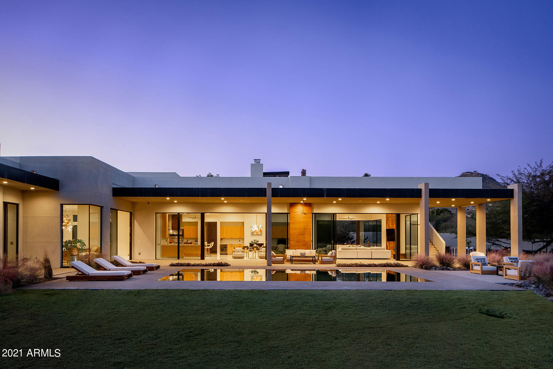 A stunning newly constructed contemporary home in the best location in Paradise Valley with ultimate privacy and views. Built for fabulous entertaining and gracious living. The chef's kitchen, open concept dining room, and large family room serve as the heart of the home. Expansive walls of floor to ceiling Fleetwood glass doors capture dead-on views of Camelback Mountain to the south and the Phoenix Mountain preserve to the north. 4 separate wings unfold to offer private living spaces starting with a generous master retreat which includes a sitting room and fireplace, a spa quality bathroom with his/hers private water closets, a large glass shower, free standing tub, and incredible closets with washer and dryer. There is a bedroom wing which can be completely closed from the center of the home; this includes three very large en-suite bedrooms all with beautiful bathrooms including marble vanities and walk-in closets. A generous guest wing provides serene private space for guests to enjoy the breath-taking landscapes and mountain views. The service wing features a mud-room, laundry room, powder room and a large office with access to the courtyard patio and fireplace. The orientation of the home maximizes views and natural light while mitigating the heat and harshness of the afternoon sun. There are five temperature controlled zones and state of the art solar panels which fuel the entire energy demand. The awe-inspiring xeriscape landscaping and Lautner edge pool is designed by the talented architects of Chen+Suchart Studio, The verdant wash on the eastern perimeter of the lot offers absolute privacy for the covered patios and roof top deck. There is a pool bathroom and shower as well. All safely located behind the private entry gate.