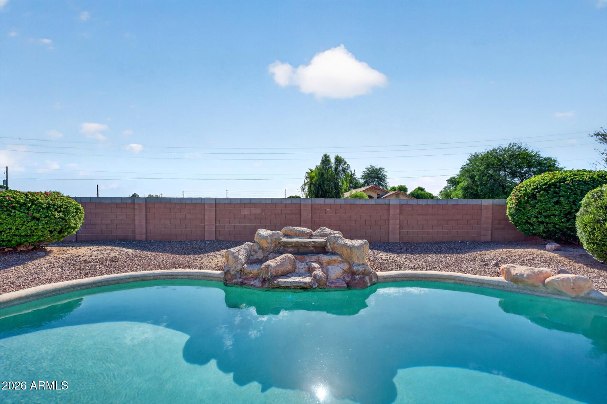 Opportunity to own a beautifully updated single-level home in the highly sought-after gated community of Legacy Estates! Situated on a spacious lot with a desirable 3-car garage, this 4-bedroom residence features a well-designed split floor plan with two generous living areas, soaring vaulted ceilings, a neutral color palette, and tasteful modern updates throughout. The bright and inviting kitchen offers white cabinetry with crown molding, abundant counter space, a pantry, and an ideal layout for everyday living and entertaining. The oversized primary suite is a true retreat, featuring double-door entry, a large picture window, a spacious walk-in closet, dual vanities, a soaking tub, a glass-enclosed walk-in shower, and a private water closet. Step outside to your private backyard oasis complete with a covered patio, sparkling pool, and extended decking--perfect for relaxing or hosting family and friends. Ideally located near Arrowhead Towne Center, the P83 Entertainment District, premier dining, the Peoria Sports Complex, convenient Loop 101 access, and just minutes from State Farm Stadium, this exceptional home offers the perfect combination of comfort, style, and location.