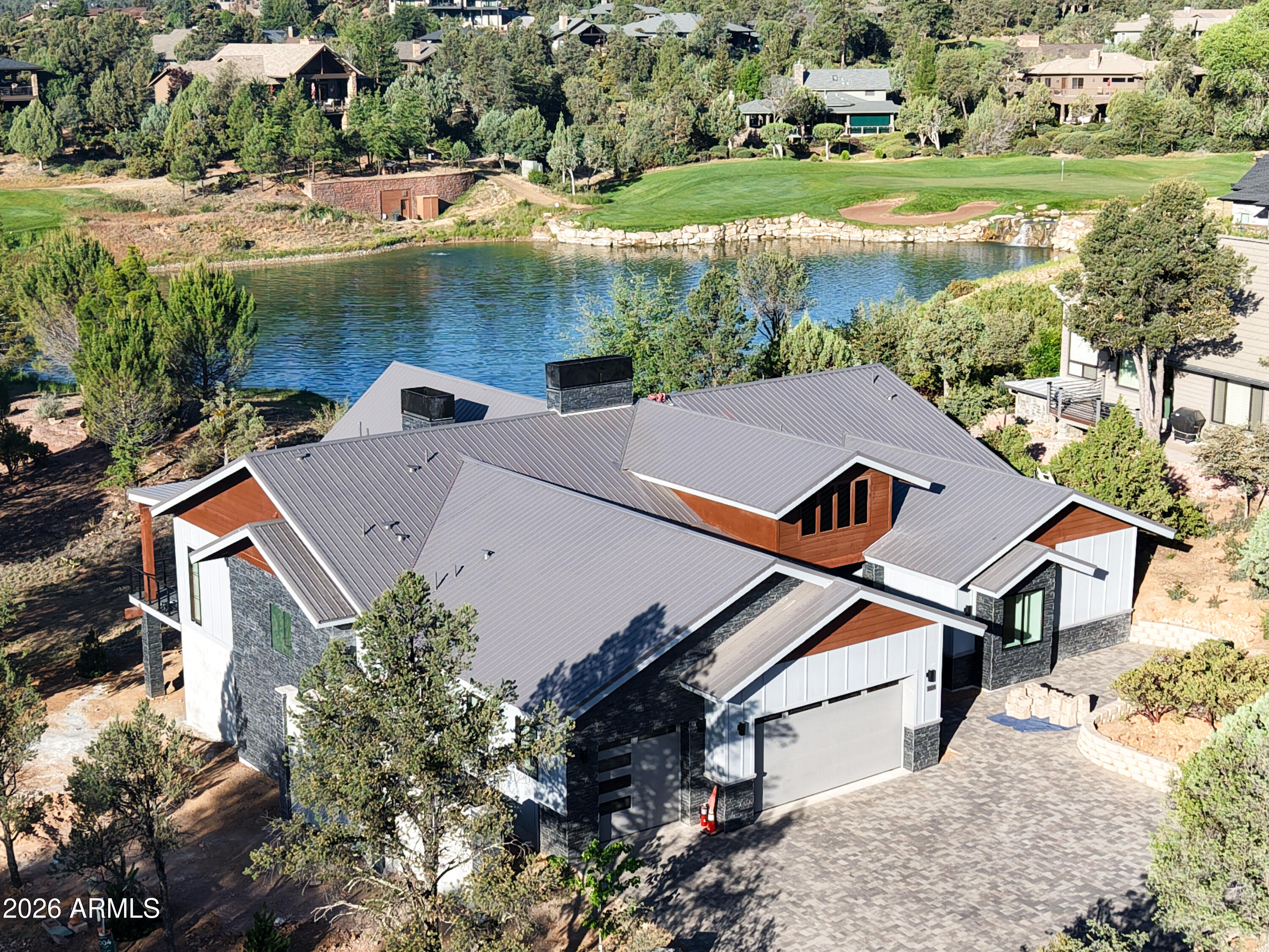 Introducing a stunning new construction opportunity in the prestigious Chaparral Pines Golf Community, perfectly positioned on a premium lot overlooking the picturesque par-3 4th hole with its shimmering lake and waterfall views. This proposed single-level residence offers timeless design, cutting-edge construction, and luxury finishes throughout and anticipated to be completed in late spring of 2026. Built with Fox Blocks Insulated Concrete Forms, the home will feature double-insulated, steel-reinforced concrete walls that deliver exceptional strength, efficiency, and peace of mind. This building system is engineered to exceed today's codes while providing superior durability, energy performance, and sound reduction, ensuring the home is as solid as it is beautiful. Finishes can be customized with an accepted offer. The thoughtfully designed floor plan offers over 3,279 square feet of livable space with four bedrooms, each with its own en-suite bath, including a luxurious primary suite with a spa-inspired bathroom and walk-in closet. Enter through a welcoming foyer and formal dining area that opens into a vaulted great room with a fireplace, seamlessly connecting to the expansive covered patio. The gourmet kitchen is the centerpiece of the home, boasting a custom hood, large island, undercounter wine refrigerator, upgraded flooring, and striking tile finishes, along with a generous pantry. Heated bathroom floors and smart-home technology, including a ''vacation mode,'' add comfort and convenience. Outside, a brick paver driveway leads to a three-car garage, while a stone-accented walkway guides you to the recessed entry porch. The home's rear elevation captures sweeping views of the golf course and pond, enhanced by cable railing on the covered deck to preserve the scenery. Combining elegance with practical design, the residence totals over 4,800 square feet under roof including porches and garage. Set within the guard-gated, master-planned Chaparral Pines community, residents enjoy access to the award-winning golf course, clubhouse dining, fitness facilities, pool, and a wide range of recreational amenities, all surrounded by the natural beauty of Arizona's Rim Country.