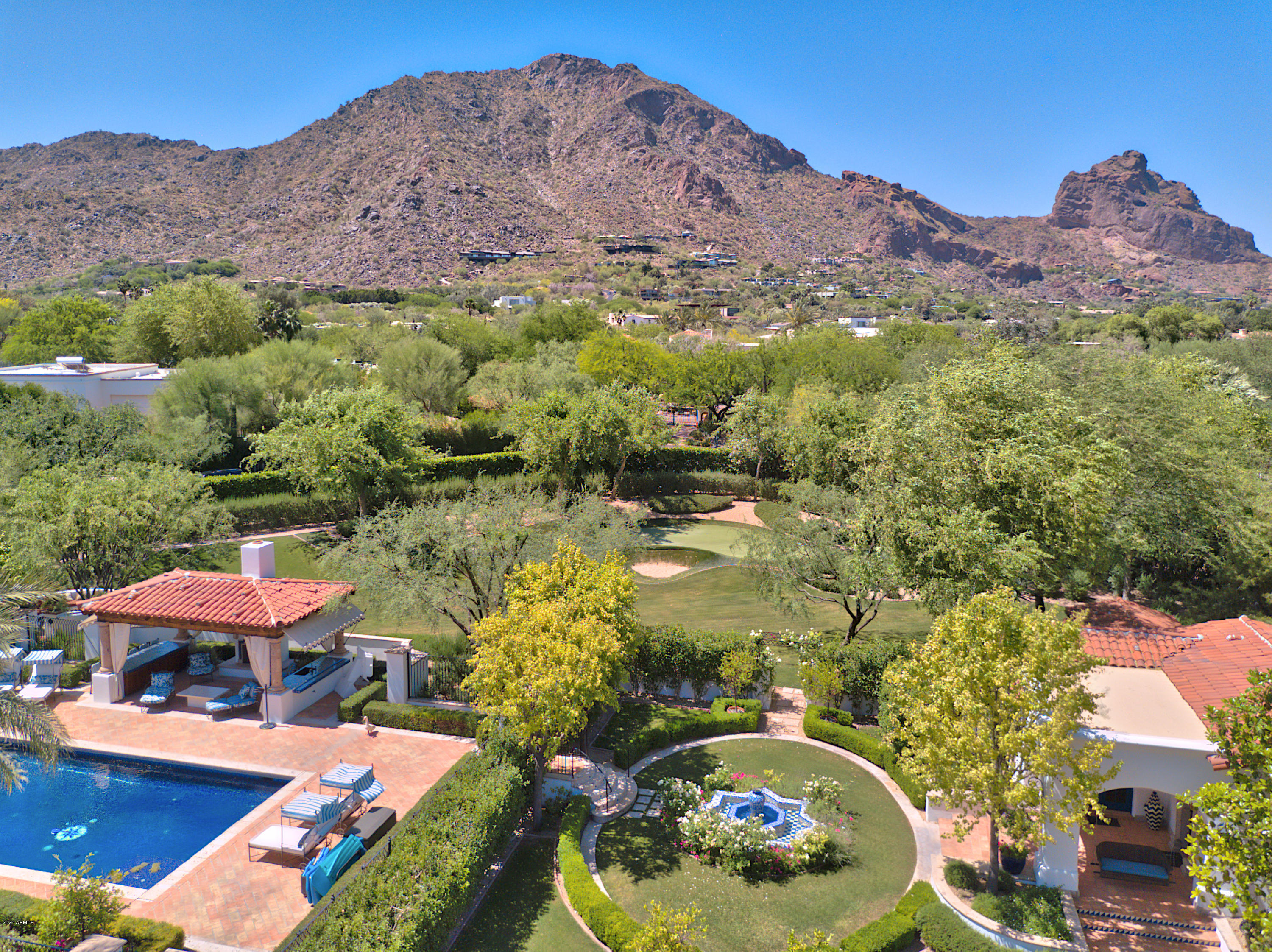 With state-of-the-art 2019 renovations and upgrades by John Schultz, a beautifully re-envisioned and chic interior by Donna Vallone, and pristine landscaping by Berghoff Design, this 2 1/4 ACRE Very Private Estate exudes cool sophistication and boasts stunning FULL CAMELBACK MTN VIEWS! Multiple French doors frame Camelback Mtn and open to the HUGE Backyard with expansive green lawns, a fully tiled pool, cabana, sport court, putting green, private jogging path + flower gardens. Highlights include 16-Ft ceilings, a FULL 2BDRM GUEST HOME, SEPARATE EXERCISE BLDG (or 2nd guest house), 2 family rms, White Designer Chef's Kitchen, an elegant 2 story library, white Carrara marble bathrms, 2 huge outdoor entertainment patios, + groin vaulted ceiling in hallways. Upgrades include  New Cabinetry, ...New Wood Flooring, Fresh High-End lighting, Savant AV system, New AC Units, Re-Done Master Closets, Brand new tile-work, fine interior paint, designer wallpaper, the list goes on! The magnificent craftsmanship, exquisite finishes, one-of-a-kind custom and imported pieces throughout, and inviting appeal make this one of the finest estates in Paradise Valley.